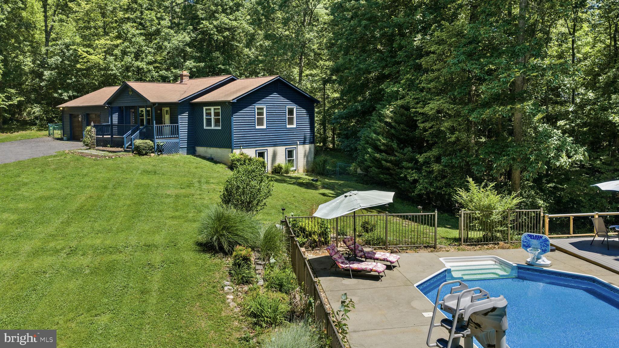 Tucked into a beautifully wooded & private setting, 247 Bootons Lane offers the perfect combination of privacy, entertaining space, and everyday comfort. This spacious four-bedroom, three-bath home was designed for gathering, relaxing, and enjoying both indoor and outdoor living to the fullest. The property’s standout feature is undoubtedly the incredible outdoor entertaining setup. From the in-ground personal pool to the expansive 13x26 rear deck, this home was built to host gatherings, celebrations, cookouts, and long summer evenings with friends. The outdoor space continues with a screened rear porch that allows for seasonal enjoyment while still feeling connected to the surrounding nature. A covered front porch adds additional charm and functionality, while the backyard provides plenty of room for firepit gatherings, outdoor games, and relaxation. An outdoor cooking and entertaining area further enhances the experience with a built-in grill and refrigerator already integrated into the patio space, creating a true backyard retreat atmosphere. Mature trees surrounding the property create a strong sense of privacy and make the entire setting feel tucked away and secluded while still remaining accessible to everyday conveniences. Inside, the home offers generous space and functionality throughout both levels. Guests frequently comment on how beautiful and impressive the home feels from the moment they walk inside. The layout provides flexibility for both everyday living and entertaining large groups comfortably. Storage is another major highlight of the property. The oversized two-car garage spans approximately 900 square feet and features high ceilings, offering excellent space for vehicles, hobbies, tools, recreational equipment, or workshop potential. Additional storage space throughout the home, including a large basement storage room, ensures there is room for everything. The screened porch has become one of the most enjoyed spaces in the home, offering a comfortable place to gather with family while enjoying the surrounding natural setting without interruption from insects or weather concerns. Important system updates provide added peace of mind, including a new water pressure tank installed in 2022, pool pump and filter replacement in 2022, new well pump in 2025, and a brand-new heat pump and AC system installed in 2026. Fun, cozy, and truly an oasis, this property has been a place filled with memorable gatherings, celebrations, and time spent with loved ones. Whether relaxing by the pool, hosting large groups, or simply enjoying the peaceful wooded setting, this home offers the kind of atmosphere that makes people want to stay awhile.