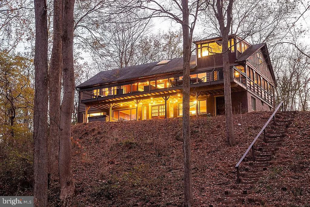 Welcome home to the Cacapon River House! Extraordinary opportunity to own a primary, secondary or investment property right on the Cacapon River. With approximately 900 feet of river acess, and sitting on just over five acres, this property offers a  private, peaceful, waterfront lifestyle right in your backyard.  Beautifully updated, this home offers a cabin vibe with all the important modern amenities. The main level of the home offers four bedrooms and one full bath with two of the bedrooms perched above the open, two story central living are and are accessed by separate, spiral staircases. This level of the home is set up for cooking, dining, entertaining and relaxing. With the living room being the central hub, the outdoors are easily accessed via an enclosed, screened in porch. From this porch, step out to the expansive deck where one can enjoy million dollar views of the river and hear the sounds of nature nearby. The lower level offers a bedroom, bathroom, kitchenette, washer/dryer and the perfect space for a pool table and fun and games. Just outside is a hot tub. Enjoy a good soak while taking in the sounds and scenes of nature. Ready for water adventure? Take the stairs down to the riverfront where you can put in your tube or kayak and explore the Cacapon River. Just a short, 20 minute drive to Berkeley Springs for dining, shopping and exploration, this home is easily accessible from Virginia, Maryland and DC.  If you're looking for R&R, the sounds of nature, river access and the opportunity to enjoy the modern conveniences this rustic cabin has to offer, then this is the place!  Improvements include a dual zone HVAC system, expanside deck, water filtration system, all electric upgrade and panels, addded stairs to river, added flooring to many rooms of the home and improved bathrooms, ceilings redone with new wood slats, screened in front porch, and added a spiral staircase connecting the two levels of the home.  The home sits outside of the floodplain. All interior funishings convey except the taxidermy and front porch hanging lamp. Please be patient with showings as this home is an active short term rental. The schedule will open up significantly in early August.