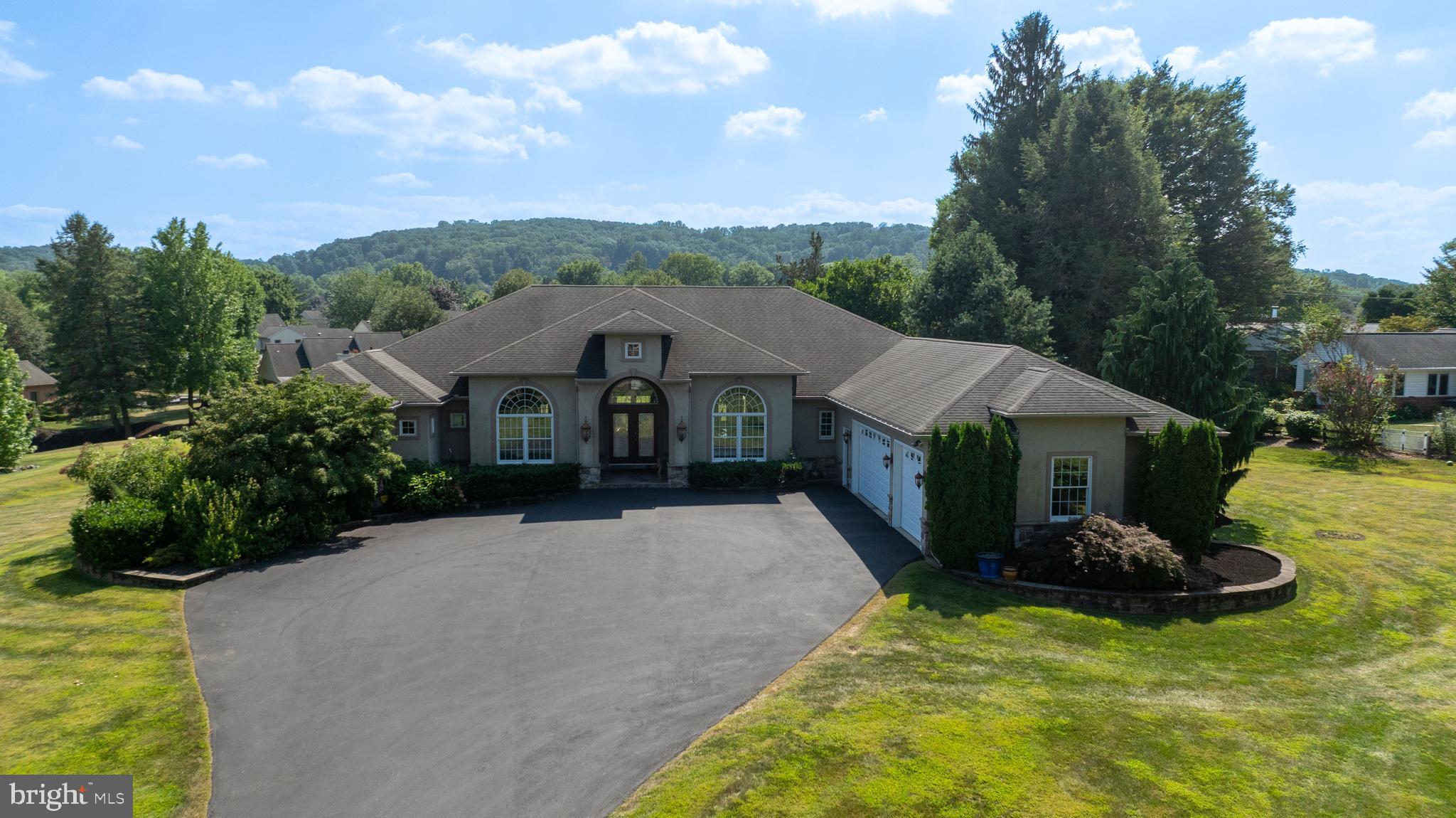 Welcome to 890 Fishburn Road!

Nestled on a sprawling 1.7-acre lot in desirable downtown Hershey, this custom-built Mediterranean-style home offers a rare blend of privacy and convenience. Located just moments from local schools and attractions, the property provides a serene retreat without sacrificing access to everything the area has to offer.

Step inside this 4,003-square-foot main level and be greeted by an open, flowing floor plan with soaring ceilings and custom lighting that enhances the home's casual elegance. The custom kitchen is a chef's delight, featuring granite countertops and high-end finishes. Tray ceilings and skylights in both full bathrooms add an extra touch of sophistication and natural light.

The residence includes four bedrooms and two and a half bathrooms on the main level. The master bedroom is a true sanctuary, thoughtfully designed as its own private wing. It features a custom closet, a luxurious en suite with a whirlpool tub, and a two-person shower. On the opposite side of the home, three additional uniform bedrooms ensure comfort and privacy.

Three gas fireplaces, two of which are adorned with beautiful marble, create a warm and inviting atmosphere. Custom decorative inserts can be found throughout the home, adding a unique and personalized touch. Enjoy the outdoors from the extra-large rear porch, which features stunning stamped concrete, perfect for relaxing or entertaining.

The lower level of this home is anything but typical. With higher ceilings and poured concrete walls, this space was crafted for both comfort and entertainment. It features a stunning, extra-large imported Italian marble gas fireplace—a rare centerpiece—and an extensive bar area.

Movie nights are elevated in the dedicated theater room, complete with a stage and surround sound. For ultimate relaxation, indulge in the custom steam sauna, which includes a shower. The lower level also boasts a half bathroom, custom Mexican doors, custom painting, and durable cork flooring, making it a truly unique and functional space. Additional features like a central vacuum system and engineered floor joists speak to the quality and thoughtful construction of this exceptional home.