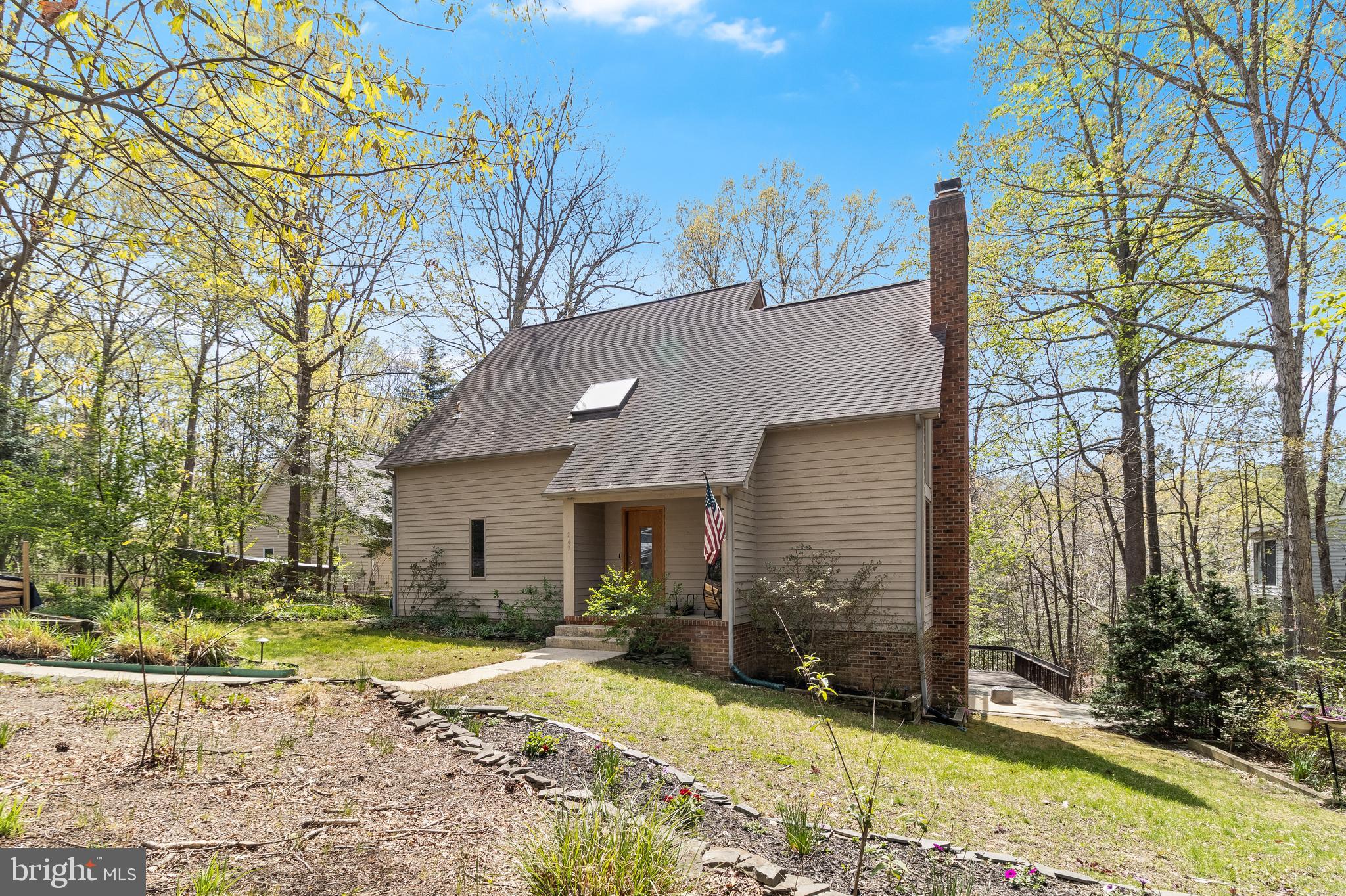 A home like something out of a novel.  A charming contemporary style house with views of Mill Creek glistening from each level. Even though this home comes with a private pier it's just walking distance from the local Marina! The centerpiece of the house is a stone covered two-story wood burning stove surrounded by large windows which makes for a warm welcome each time you step into your home. The main bedroom leads you out  back where you will find expansive multiple decks and outdoor seating areas that are perfect for entertaining!  More recent updates include a remodeled kitchen  with stainless steel appliances and wall ovens and bathrooms with ceramic tile flooring. The primary bathroom equipped with a walk-in tiled shower and overhead rain style shower head.

Head upstairs to your cozy loft lit with abundant natural lighting from the skylight above. The remaining bedrooms have large windows and a balcony for all to look out and enjoy the scenic views of the surrounding woods and water. 

In the walk-out level basement you will find an additional wood fire place. A separate bar with sink and  a large open area and the sliding glass door which leads you out to the beautiful stone patio sitting area and walk way down to the private pier!