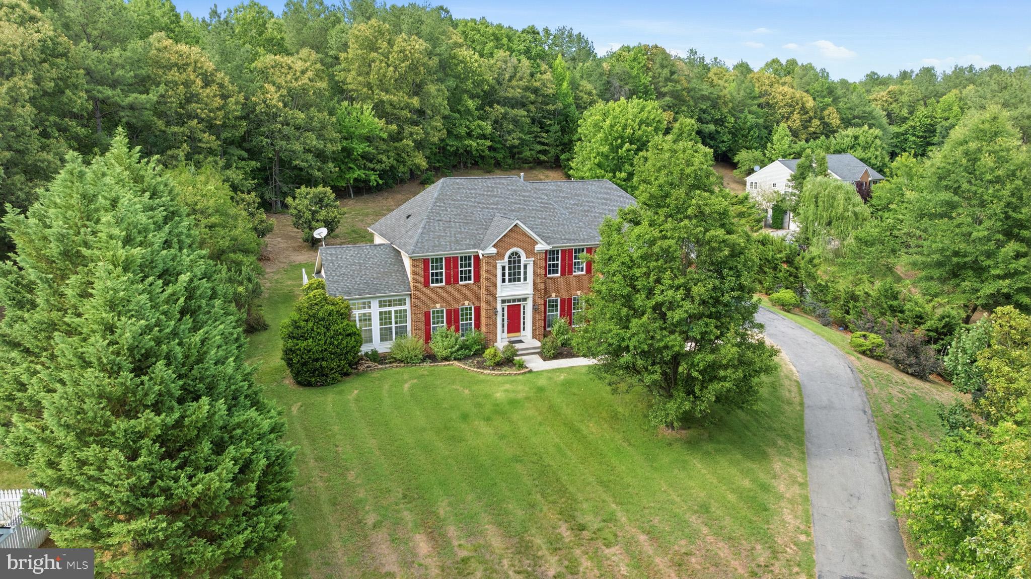 BIG BOLD BEAUTY!  Welcome to this impressive brick-front Colonial offering nearly 5,000 square feet of living space on over 2 private acres. A grand two-story foyer creates a stunning first impression. Main level boasts a gourmet kitchen that opens up to the morning room and overlooks the grand 2 story family room. A formal dining room, formal living room, office, and sun room complete the main level. Use the main or back staircase to the upper level where you’ll find a primary suite with sitting room, 2 walk in closets, and a lux en suite. Bedroom 2 features a private bath, and Bedroom 3 & 4 share a jack-n-jill bath. The finished lower level provides exceptional versatility with a basement apartment, recreation room, additional living space, and endless possibilities for multi-generational living, extended stays, or entertaining. Surrounded by mature trees and situated on over two acres, this property offers the perfect balance of privacy, space, and elegance while remaining convenient to shopping, dining, and commuter routes (to DC, NOVA & the National Harbor). A rare opportunity to own a home that truly has it all.