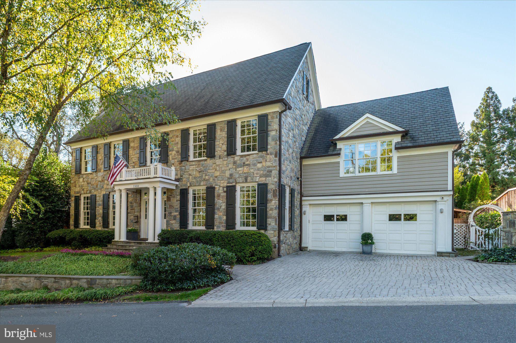 Ideally located in the coveted Kent neighborhood of Washington, DC, this extraordinary custom stone residence by Jim Gibson blends timeless elegance with modern luxury. Offering approximately 10,000 square feet of beautifully finished living space on a rare 10,650-square-foot flat lot, the home sits directly across from the 37-acre Battery Kemble National Park, providing an exceptional sense of space and serenity. Designed for both grand entertaining and comfortable daily living, the home features 10-foot ceilings, expansive formal and informal spaces, and a gourmet eat-in Kitchen that opens seamlessly to the Family Room. The gracious Foyer and Gallery set a tone of understated sophistication, leading to a spacious Living Room and Dining Room ideal for gatherings. The cathedral-ceiling Primary Suite offers a peaceful retreat with two walk-in closets and a luxurious spa bath, complemented by three additional en-suite bedrooms on the same level. A newly added upper floor provides nearly 1,000 square feet of flexible space—perfect for a private office, studio, or guest suite—with an additional bedroom, full bath, and storage. The Lower Level features 8’8” ceilings, a Family Room, Exercise Room, Craft Room, and another Bedroom with En-Suite Bath. Outdoors, resort-style amenities include a 46’ x 18’ pool, outdoor sauna and shower, covered terrace with skylights and fans, and multiple spaces for grilling and entertaining. A two-car garage and additional driveway parking complete this remarkable offering—an elegant, effortless escape in one of DC’s most sought-after settings.