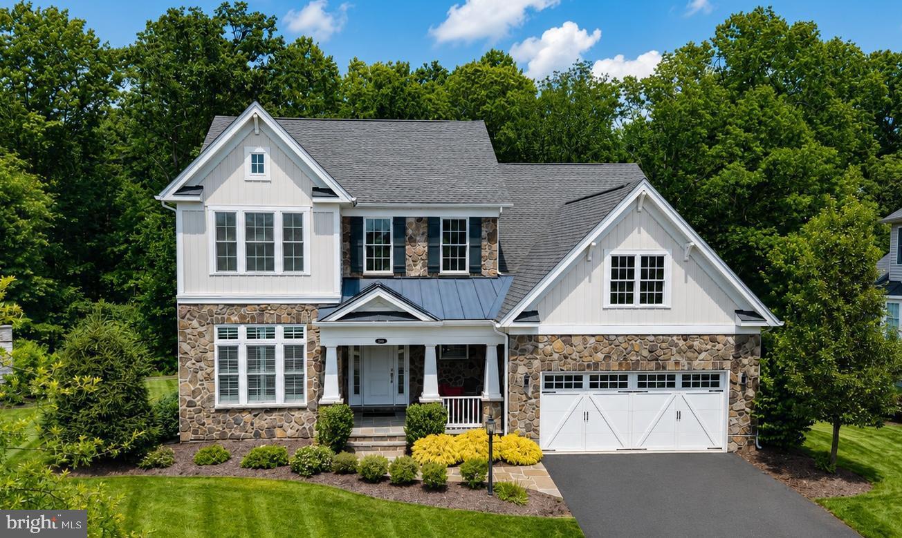 Tucked away on one of the most desirable lots in the Villas, this exceptional Bridleridge model combines luxury, comfort, and privacy in a peaceful cul-de-sac setting backing to mature trees and scenic walking trails. Offering nearly 5,700 sq ft this home delivers the rare combination of expansive indoor living and a backyard setting that feels worlds away from the everyday. A charming covered front porch, stone exterior, flagstone walkway, and highly sought-after single two-car garage door create an impressive first impression. Inside, soaring ceilings, rich hardwood flooring, plantation shutters, designer lighting, and abundant natural light elevate every space. The dramatic two-story family room serves as the heart of the home, highlighted by a wall of windows and a unique three-panel sliding glass door with motorized shades and screens that seamlessly connect indoor and outdoor living. Designed for both entertaining and everyday enjoyment, the gourmet kitchen features a massive center island, premium appliances, double wall ovens, stylish countertops, and a sunny breakfast area complete with a custom built-in cushioned bench. The formal dining room offers the perfect backdrop for holiday gatherings and special occasions.
The main-level primary is a true retreat, featuring two walk-in closets and a luxurious bath with an expanded dual-head shower. A private home office and a second main-level bedroom with a walk-in closet provide flexibility for guests, multi-generational living, or work-from-home needs. Built-in ceiling speakers throughout the home add an extra touch of convenience and sophistication.
Upstairs, two additional bedrooms, a spacious loft, and a large storage room offer plenty of room for family and guests. The finished walkout lower level expands the living space even further with 9-foot ceilings, a spacious recreation room, half bath, wet bar rough-in, and a large unfinished area ready for a future fitness room, hobby space, or additional living area.
Outside, the flat backyard is a rare find in Dominion Valley Country Club, offering usable outdoor space, wooded views, and direct access to community walking paths. Additional features include an irrigation system and whole-house water softener. A truly special opportunity to enjoy low-maintenance living without sacrificing space, privacy, or luxury.