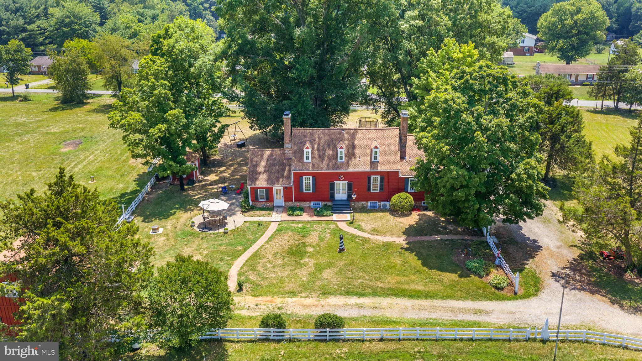 Steeped in foundational American heritage, this monumental 6.06-acre Fredericksburg estate offers a once-in-a-lifetime opportunity to own a living piece of history. Originally constructed in 1723, this extraordinary property was once built by Colonel William Ball as a wedding gift for his son William, the uncle and cousin of Mary Ball Washington (mother of George Washington).  The Ball family lived in this home continuously until 1919 when it was sold.  Adding to its profound historical significance, the estate directly fronts Chapel Green Road—a historic thoroughfare constructed by Union Forces during the Civil War. The architectural soul of the home rests in its original 17th-century central structure, which stands as a masterclass in preservation. Inside this historic core, you will find stunning woodwork and craftsmanship original to the home, including authentic trim work, doors, substantial doorway casings, windows, historic chimneys, rich wood flooring, and original staircases that tell a story spanning over three centuries. To accommodate modern living, two expansive wings were seamlessly added during the late 1970's and early 1980's, creating an incredibly versatile and spacious floor plan. The main residence is perfectly laid out for comfort and function, highlighting a coveted first-floor primary bedroom suite for ultimate convenience. The interior unfolds to offer two additional upper-level bedrooms, 2.5 bathrooms, 6 total fireplaces,  a bright and airy sunroom, a generous  renovated kitchen, and a dedicated family room. Designed with entertaining in mind, the home features two distinct, large living rooms (Living Room #1 and Living Room #2), providing an abundance of flexible gathering spaces. Beyond the main home, the park-like acreage transforms into a premier equestrian or agricultural haven. The property features a fully equipped 4-to-6-stall barn complete with a dedicated tack room, alongside two expansive, securely fenced paddocks ready for horses or livestock. An incredible asset to the estate is the completely independent, detached second home. This fully autonomous guest house boasts two spacious bedrooms, two bathrooms, a full kitchen, and its own cozy living room—offering a highly lucrative opportunity for multi-generational living, a caretaker’s cottage, or premium rental income. This property has been featured in several news articles and is listed in several historic property books written about Stafford County.  Currently the property is being researched and verified by the Virginia Historians Office. Do not miss the chance to become the next steward of this legendary Virginia treasure!  Just minutes from downtown Fredericksburg, a quick drive to Leeland and Fredericksburg commuter rails. Easy commute to Dahlgren, Quantico and more.