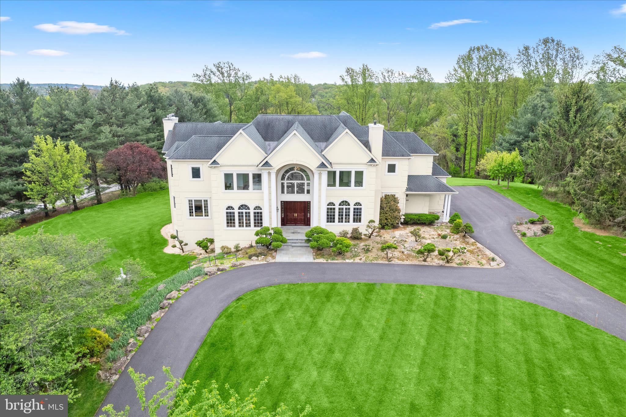 Tucked away on a pristine three-acre lot surrounded by mature trees and lush greenery in the sought-after Nicholson Farms neighborhood, this exceptional residence offers five bedrooms with five and a half bathrooms across beautifully appointed living spaces. Meticulously manicured grounds create a stunning first impression, while a covered front portico welcomes you to double doors that open into a soaring two-story foyer adorned with marble flooring. An abundance of natural light fills the home through large windows, highlighting tall ceilings, a neutral palette, and elegant trim moldings, with rich hardwood floors flowing throughout the main level. Designed for both everyday living and upscale entertaining, the front living room features a gas fireplace, while the spacious formal dining room connects to the kitchen through a butler’s pantry. The eat-in kitchen showcasing granite countertops, 42-inch cabinetry, a center island with seating, pantry, and high-end appliances including a Sub-Zero refrigerator/freezer and a Thermador Professional six-burner range with griddle and double ovens. Just beyond, the family room offers a warm and inviting setting with a wood-burning fireplace and a breakfast nook with sliding glass doors leading to the deck, where serene wooded views provide a picturesque backdrop. A private office creates the perfect work-from-home environment, while a main-level bedroom suite with a walk-in closet and ensuite bathroom offers flexibility for guests or multigenerational living. A half bathroom and a well-equipped mud room with laundry, multiple closets, and access to the three-car garage and side entrance, finishes the main level. An elegant staircase leads to the upper level, where the expansive primary bedroom suite serves as a luxurious retreat, complete with a gas fireplace, breathtaking views of the surrounding treeline and scenic vista, and a massive walk-in closet. The primary bathroom boasts marble tile and features dual vanities, a jetted soaking tub, a walk-in shower, and a private water closet. Down the hall is another bedroom suite with its own walk-in closet and private bathroom. Positioned on the opposite wing of the upper level are two additional bedroom suites, each with walk-in closets and ensuite bathrooms. A versatile sitting room on this side of the home provides a flexible space, with a secondary staircase leading downstairs to the mud room. The upper level also has a large floored attic with abundant storage. Downstairs, the partially finished walk-out lower level presents endless possibilities to customize and suit your needs, anchored by a massive recreation room with a gas fireplace. A versatile den along with a potential sixth bedroom suite with a walk-in closet and attached bathroom further enhance the space and options. Multiple utility rooms also add more indoor storage. Outdoor living is equally impressive, with a spacious deck and a ground-level patio overlooking the expansive private backyard with room for everyone’s activities. Additional highlights include six-zoned heating and cooling systems, a central vacuum, 75-gallon water tanks, and more, offering comfort, efficiency, and convenience throughout this remarkable home.