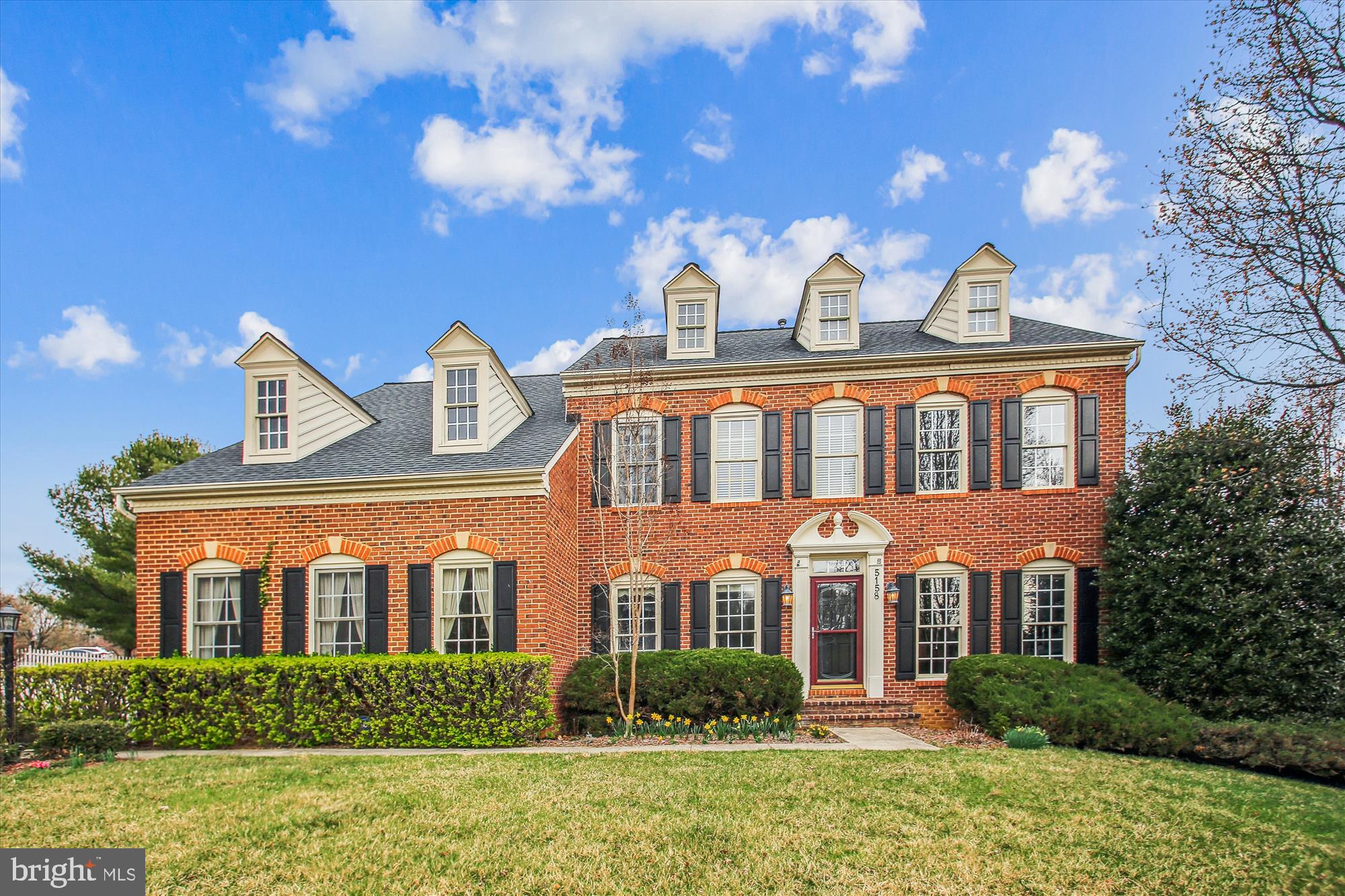 Nestled on a spacious corner lot in the highly coveted Crestwood community, this exquisite brick-front colonial offers an abundance of living space, elegant upgrades, and timeless charm. Step inside the lovely foyer, where two stories of windows flood the space with natural light. Newly refinished hardwood flooring enhances the foyer’s grandeur, seamlessly extending into the living and dining room areas. Freshly painted, both rooms exude sophistication with custom crown molding and chair rail accents. The gourmet kitchen is designed to impress, boasting updated appliances in last 5 years, custom-painted wood and glass front cabinetry, a stylish tile backsplash, granite countertops and island, double wall oven, and gleaming hardwood floors. Thoughtfully placed recessed and pendant lighting enhances the warm and inviting ambiance. The adjoining breakfast area leads to the bi-level deck, ideal for outdoor dining and entertaining, and connects to the sunken family room, where a cozy fireplace with classic mantel and marble surround, wraparound windows adorned with custom shutter treatments, and brand-new neutral carpeting create a perfect gathering space. Ascend the beautiful split staircase with hardwood to the upper level, where a charming sitting area with built-in shelving and cabinetry awaits. The luxurious primary suite features gleaming hardwood floors, a grand double-door entry, a ceiling fan with lighting, and a spacious walk-in closet. The freshly painted en-suite bath offers a walk-in shower, a corner soaking tub, dual vanities, and vaulted ceiling. Three additional generously sized bedrooms with hardwood flooring, and a well-appointed second full bath, all freshly painted, complete this level. The walkout lower level extends the home’s incredible living space, featuring a recreation room with brand-new neutral carpeting and French doors leading to the beautifully enclosed yard with classic white picket fencing. A stylish third full bath on this level showcases wainscoting, fresh paint, and a tub/shower combination. A side-entry 2 car garage with windows enhances both functionality and curb appeal. Additional amenities include the architectural shingle roof (2020), and a dual-zoned HVAC system.