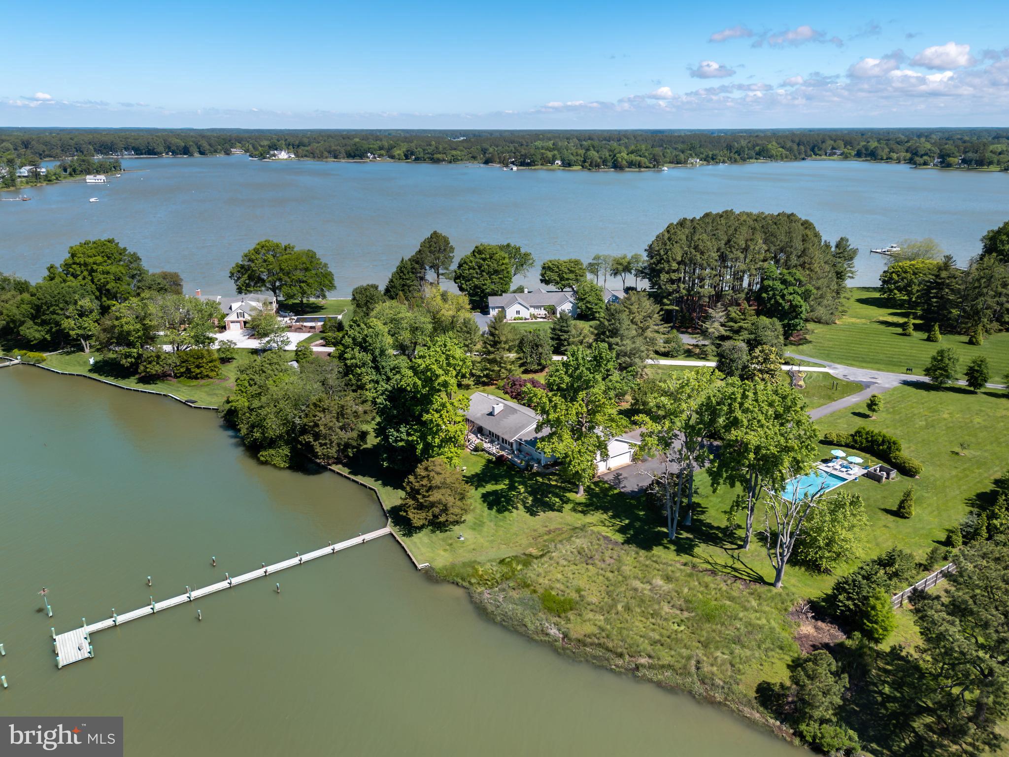 Waterfront living at its finest in Pirate’s Cove, tucked along the serene waters of Trippe Creek. Set on 2.71 waterfront acres and beautifully sited across from a nature preserve, this property offers serenity, sophistication, and sweeping water views. Built in 1986 and thoughtfully reimagined with a custom renovation in 2016, the home blends elegant design and modern comforts in a meticulously maintained, one-level layout featuring three bedrooms and three full baths. Vaulted ceilings and walls of windows fill the living spaces with natural light, creating a bright, open atmosphere throughout. Overlooking the water, the gourmet kitchen is a chef’s delight, featuring a Wolf range with warming drawer, Sub-Zero refrigerator, double wall ovens, quartzite countertops, generous cabinetry, and a spacious island perfect for gathering. The living room, kitchen, and primary suite are all sun-drenched and open seamlessly to the deck, providing stunning water views and creating effortless indoor-outdoor living. The primary suite is a tranquil retreat with expansive water views, a large walk-in closet, and a spa-like en-suite bath highlighted by a stone soaking tub, glass-enclosed shower, and a unique laundry-chute window that connects directly to the laundry room for added convenience. Outside, enjoy summer days by the salt water, in-ground pool or stroll down to your private pier with approximately 4' MLW—ideal for boating, kayaking, or simply soaking in the peaceful setting. A large attached three-car garage provides ample space for vehicles, storage, and waterfront gear. This is the essence of Eastern Shore waterfront living—refined, relaxed, and ready to be enjoyed.