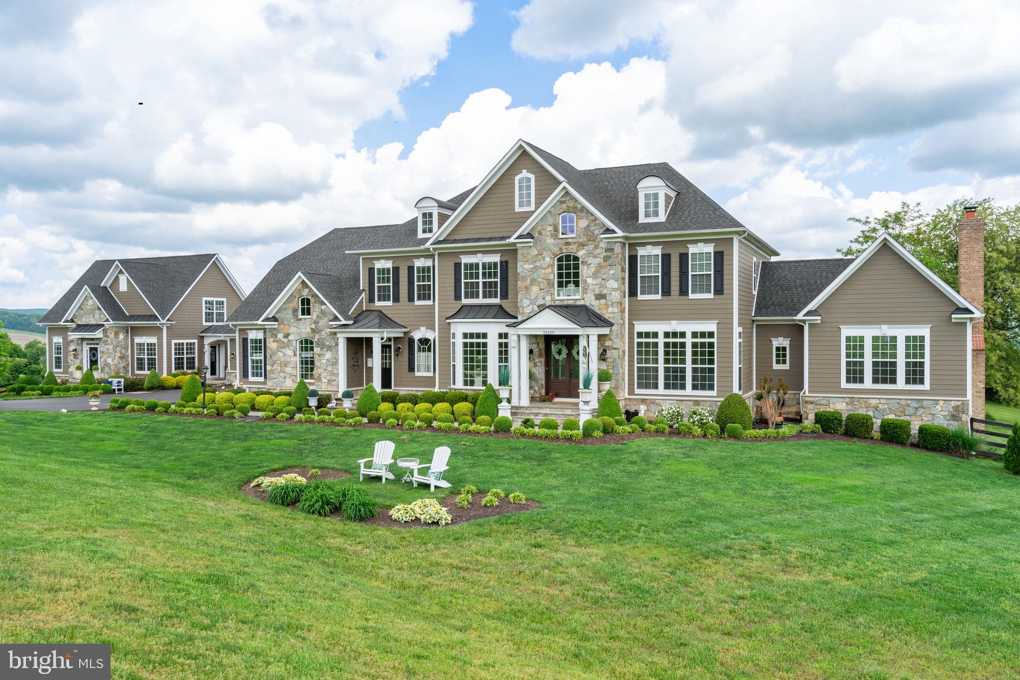 CHOSEN AS LOUDOUN TIMES-MIRROR HOME OF THE WEEK! Spectacular Mountain Views from  this Multi-Generational Carrington Model Home with 9600+ sqft Main house, with 6 BEDROOMS & 6.5 BATHS, alongside a three-level, 2400+ square foot Guest House, with 3 BEDROOMS & 3.5 BATHS, 

Located :  Mins From some of Northern Virginias Best Vineyards, 12 Mins to downtown Purcellville; 20 Mins to Market St (Downtown Leesburg); 32 Mins to Loudoun Gateway Metro Station;  Just under 40 Mins to Dulles Airport.

With mature landscaping and private culture-de-sac  this magnificent residence is a statement of exceptional craftsmanship and elegance, offering breathtaking panoramic vista views . The Main house spans three levels and features six ensuite bedrooms, including one on the main level, exuding lavishness and comfort. Meanwhile, the thoughtfully designed guest home provides an additional three ensuite bedrooms, catering to the utmost privacy and luxury for guests, with a first-floor primary suite adding to its allure. INTERNET: Verizon FIOS with Whole House Data LAN gigabit cable throughout property.  WHOLE HOUSE GENERAC GENERATOR. 

Every inch of this estate is a showcase of craftsmanship beyond compare. Hand-scraped Hickory hardwood floors, soaring 10-foot ceilings, majestic 8-foot doors, exquisite wood moldings, and four magnificent floor-to-ceiling stone fireplaces (3 Gas and 1 wood burning) create an ambiance of unparalleled luxury. With mountain views from EVERY window and natural light flooding every inch of the interior.

With main-level opulence offering formal dining, living, a gourmet kitchen, a family room, a great room (currently used as an office) a hall gallery, and a coffee bar—all seamlessly blending to provide the ultimate in entertainment spaces. The gourmet kitchen is a chef's dream, equipped with top-tier stainless steel appliances, CLASSIC custom maple glazed cabinets, and opulent granite countertops, while the sunlit morning room offers a serene backdrop for starting the day.

On the second floor you'll discover four exceptionally spacious ensuite bedrooms, each adorned with walk-in closets. The sumptuous Primary suite is a tranquil oasis, complete with a sitting room, spa-like Primary bath, and a vaulted ceiling adorned with a designer chandelier, offering the ultimate retreat for the discerning homeowner.

The lower level with its vast entertainment haven, features a game room, exercise room, bonus den, and a stadium-style movie theater, perfect for hosting gatherings or unwinding in luxury. 

Outside, the sprawling backyard offers a firepit and hot tub, with potential for a pool or additional outdoor sanctuaries.

For horse enthusiasts, the property boasts a custom horse run-in barn, tack room, wash bay, and charming chicken coop, all enclosed within 4-board oak fencing and meticulously groomed pastures. An abundance of outdoor storage spaces include a custom storage barn with loft space for storage and two additional storage sheds located behind the guest house. 

With a state-of-the-art whole estate generator providing year-round peace of mind, this secluded retreat in Loudoun County's esteemed horse country offers effortless access to upscale amenities and is a haven for those seeking an idyllic lifestyle.
