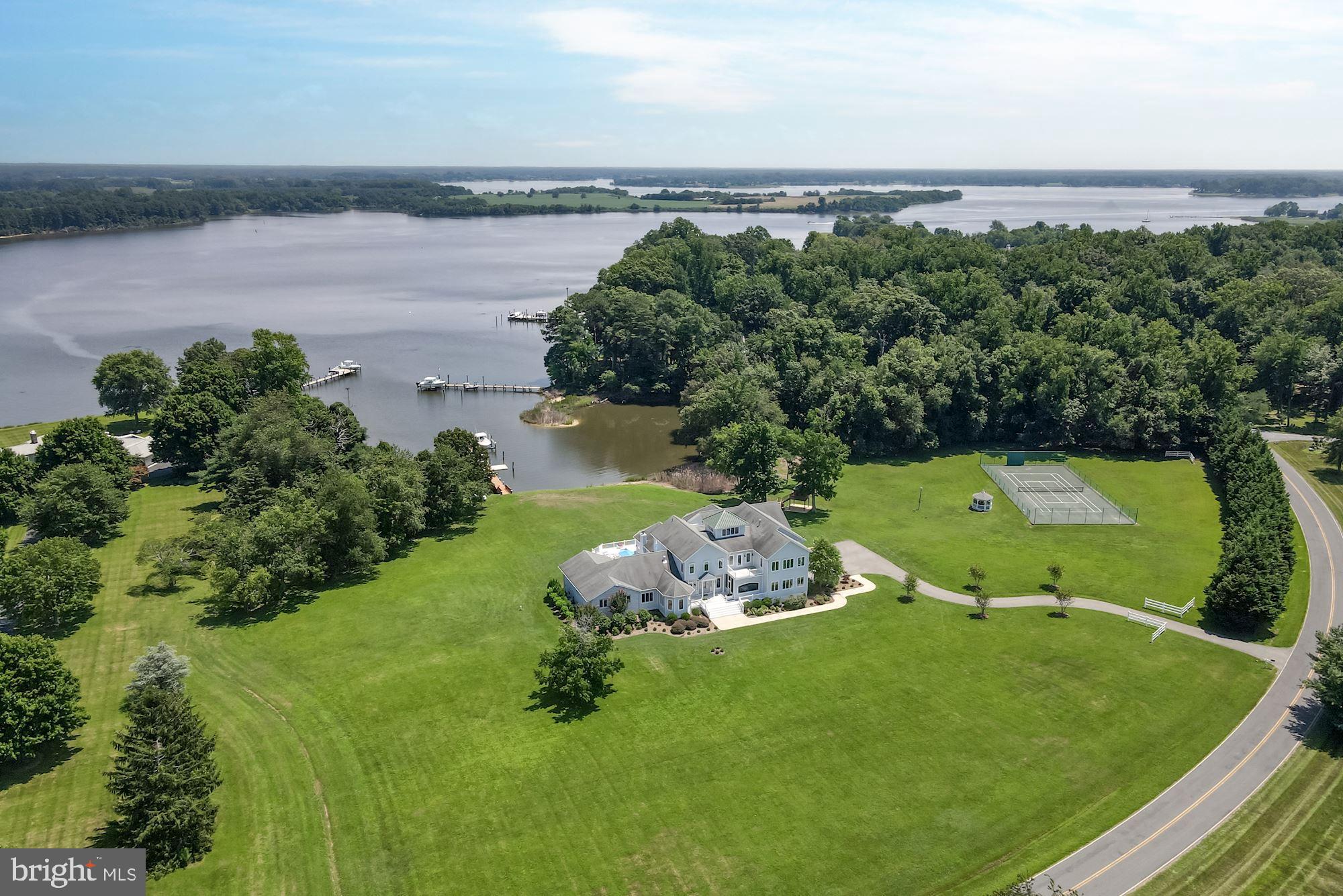 Spectacular contemporary waterfront estate on 5.7+ private acres with 250 +/- feet of rip rapped waterfrontage on the Wye River. Situated in the private and exclusive Bennett Point peninsula, the home offers stunning water views of the Wye River to the east and the Chesapeake Bay to the west. 

Highlights include approximately 11,000+/- sq.ft of living space, 7 Bedrooms, 8.5 updated Baths, indoor salt-water pool, elevator, rear trex-type deck, tennis court with gazebo, treehouse, 2-car attached garage, pier with 2 boat  lifts and slips, and updates throughout. 

The main level features a sunbathed open floor plan foyer, leading directly to the dining room and grand living room with wood burning fireplace and multiple exposures overlooking the water. The updated gourmet eat-in kitchen with breakfast area offers large island with bar seating, Thermador & Viking stainless steel appliances, granite topped counters, sitting area, and a walk-in pantry. Off the kitchen are 3 bedrooms, 1 with ensuite bathroom, and an additional bathroom. The main level is completed by his & her office, screened front porch, powder room, elevator to 3 levels, saltwater pool with desert air climate control & retractable cover, walk-in sauna & full bathroom, laundry, and large 2-car garage. 

The second level offers the primary suite, 3 additional bedrooms with ensuite bathrooms, laundry room, balcony overlooking the Wye, open exercise area, and elevator access. The large primary suite has a gas fireplace, two large walk-in closets and direct access to the laundry. The upgraded luxurious primary bathroom features a double vanity, separate seamless glass shower, free standing tub, powder room, and access via double doors to a large balcony overlooking the rear yard and Wye River. 
The 3rd level offers a large crow’s nest with wet bar and is a perfect spot to enjoy 360-degree views east across the Wye River towards the Wye River Nature Preserve, south down Bennett Point, and west to the Eastern Bay. 

The main house is completed by a full lower level with access via staircase, elevator, and walk-out stairs. Offering a theater room, game area with wet bar and dishwasher, billiard area, bonus room that can be used as a bedroom, full bathroom, and ample storage. 

Set on 5.7+ acres the private property features mature landscaping, a first-class tennis/pickle ball court with a new screened gazebo, hot tub, tree house, redone dock with two lifts (25,000lbs, 1,500lbs) and a paddle board launching float, paddle board rack, natural shoreline. Easy access to Washington DC, Annapolis, Easton, St. Michael, Baltimore, 2 Hours from Philadelphia, and less than 4 hours from New York City.

All interion/exterior furnishings available for purchase separately.
