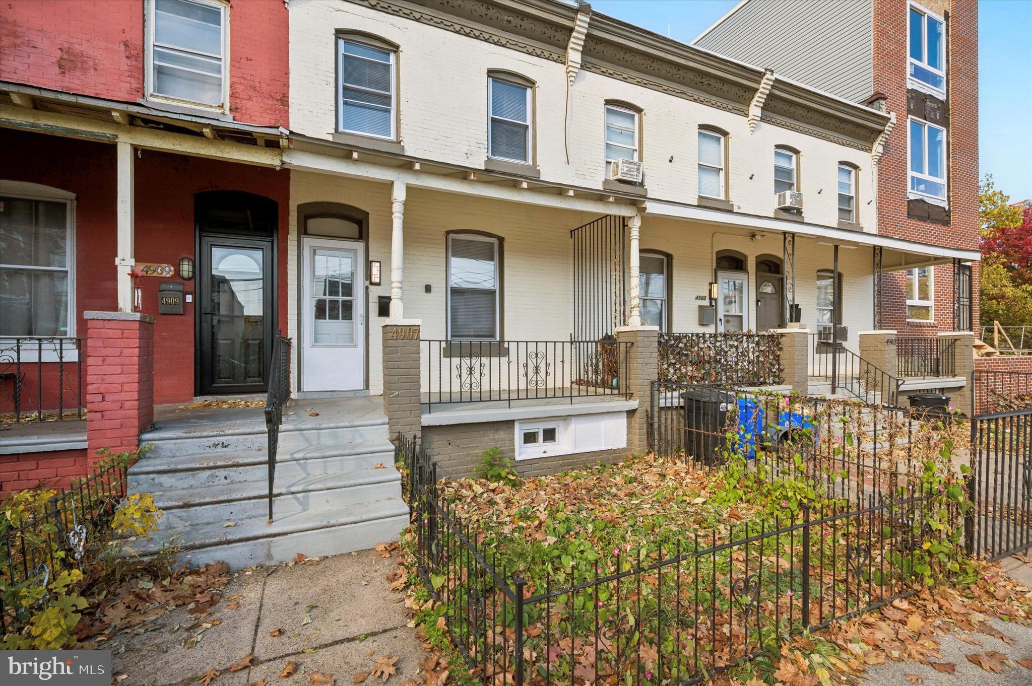 This charming, move-in ready porchfront rowhome is in a great location near Cedar Park and the Grays Ferry Bridge. The cream and sage green palette highlights the ornate trim work on the facade, which is set back behind a true front lawn. The interior gets great natural light and has charming original details like random-width pine floors and ornate radiators throughout. The spacious living room has an extra-large archway, which joins it to the open dining room and kitchen. The workspace has new large-format ceramic tile floors, granite countertops with stainless steel undermount sink with pulldown faucet; and crisp white Shaker-style cabinets, subway tile backsplash and appliances. In the rear there’s an extra-large mudroom with new vinyl flooring, laundry hookups and sliders to the covered rear patio and good-sized yard–not to mention a perfectly located powder room. Up the cute black and white staircase is the bathroom with ceramic subway tile surround and new vinyl flooring next to a sweet rear-facing bedroom.The true middle bedroom has a private side window. The large, south-facing primary bedroom with double-width closet is past an extra-deep hallway linen closet. This block of Paschall Ave is just a few blocks to Clark Park; local shops and restaurants line nearby Woodland Ave; two trolley lines are just around the corner; proximity to the Grays Ferry Bridge gets you to South Philly in 10 minutes; and outdoor enthusiasts can enjoy the Grays Ferry Crescent Trail Park and Bartram’s Garden nearby. We used to call this neighborhood West Philly’s best-kept secret, but with all the new development on the block and in the immediate area, that description can be retired.