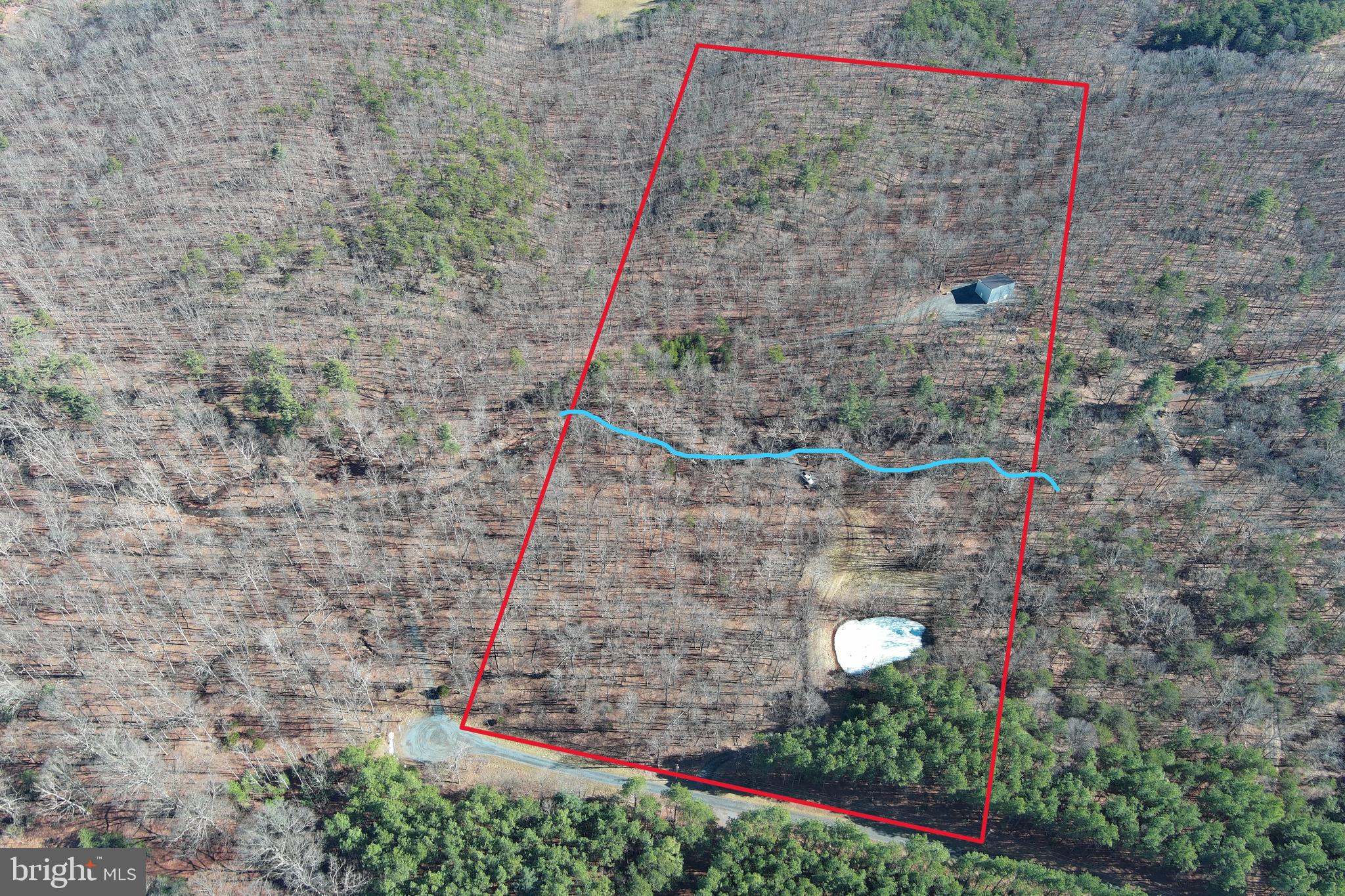 MODERN BARNDO SHELL ON "SAWMILL RUN".....20 ACRES OF PRIVATE PARK LIKE PARADISE....100% USABLE LAND COVERED IN WHITE OAKS WITH SPRING FED POND AND 600+ FT OF "SAWMILL RUN" FLOWING THROUGH THE MIDDLE OF THE PROPERTY. 1000 FT DRIVEWAY LEADS YOU ACROSS THE STREAM TO THE HOME/CAMP SITE ON RIDGE, WITHIN SITE & SOUND OF STREAM. ALL UTILITIES IN PLACE; UNDERGROUND ELECTRIC, WELL & 3 BEDROOM SEPTIC.....READY TO PULL IN & PLUG IN YOUR CAMPER SO YOU HAVE A PLACE TO STAY WHILE FINISHING THE CABIN TO YOUR TASTE. 30X40 STEEL BARNDO/CABIN SHELL WITH POURED FLOOR & PLUMBING IN PLACE. FLOOR PLANS AVAILABLE FOR 3 BED 2 BATH 1.5 STORY LAYOUT......BUT THE BEAUTY OF THIS TYPE OF STRUCTURE IS THAT THE INTERIOR LAYOUT IS ONLY LIMITED BY YOUR IMAGINATION. HOW MUCH WILL IT COST TO FINISH THE INSIDE? DEPENDS ON YOUR TASTE BUT 125K WOULD PROBABLY BE A REALISTIC BUDGET.....DO THE MATH, IF YOU END UP WITH 1500+ SQ FT OF BRAND NEW LIVING SPACE ON 20 STREAM FRONT ACRES FOR 400K......YOU'RE GONNA BE IN AN INCREDIBLE EQUITY POSITION......500K PROBABLY WOULDN'T SNIFF SOMETHING LIKE THAT IN THIS MARKET! EASY ACCESS TOO, ONLY 1/2 MILE OFF THE PAVED ROAD BUT FEELS LIKE YOU'RE 10 MILES IN..... LOCATED IN THE PRESTIGIOUS 10,000 ACRE GATED COMMUNITY ASHTON WOODS, A ONE OF A KIND PLACE, WHERE YOU CAN ESCAPE THE WORK & WORRY OF THE BIG CITY AND TICKLE ALL YOUR OUTDOOR FANCIES....15 MINUTES OFF 4 LANE SUPER HIGHWAY, 10 MINUTES FROM MULTIPLE PUBLIC ACCESS POINTS ON THE SOUTH BRANCH OF THE POTOMAC RIVER, 10 MINUTES FROM MOOREFIELD, 45 MINUTES FROM SKI RESORTS, 10 MINUTES FROM PRIVATE COMMUNITY ACCESS TO NATHANIEL MOUNTAIN WILDLIFE MANAGEMENT AREA 10,000 ACRES OF PUBLIC HUNTING & HIKING.....IF YOU LIKE THE OUTDOORS, YOU'LL NEVER RUN OUT OF THINGS TO DO.....WHO KNEW? ALL OF THIS WITHIN 2 HOURS OF DC.....BELIEVE IT! IF YOU'RE CREATIVE & HANDY.....THIS PLACE IS A SLAM DUNK. THE LAND IS TOP SHELF AND WOULD EASILY FETCH 150K WITH ZERO IMPROVEMENTS. THE INFRASTRUCTURE THAT'S IN PLACE WOULD CONSERVATIVELY COST YOU 60K.....LIKE I SAID, DO THE MATH.....THIS PLACE ADDS UP TO A WINNER EVERY TIME!