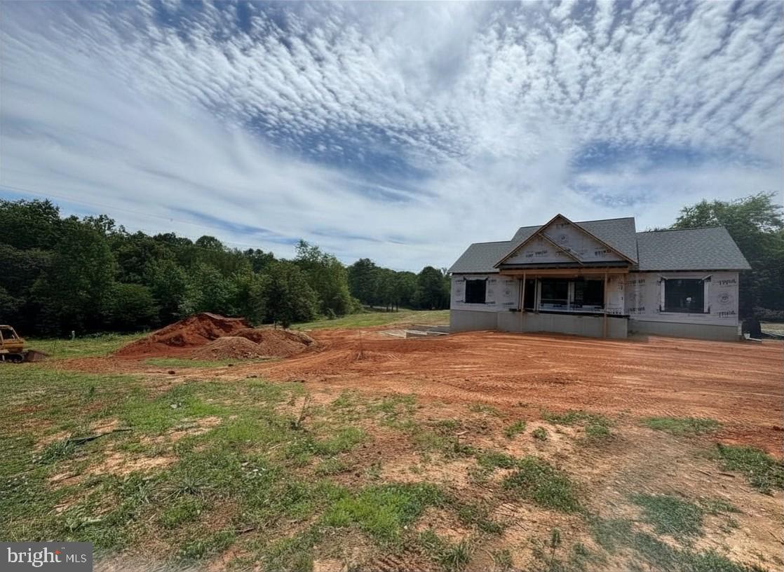 Welcome to a brand new Custom Craft Homes creation where quality craftsmanship, exceptional space, and an unbeatable location come together. Offering more than 3,000 finished square feet with over 1,500 square feet on both the main level & finished walk-out lower level, this thoughtfully designed home provides impressive flexibility. The open-concept floor plan features soaring vaulted ceilings that connect the family room, dining area, and upscale kitchen. Quartz countertops, abundant cabinetry, a spacious island, and luxury vinyl plank flooring throughout the home ensure timeless style with low-maintenance living. Ceramic tile finishes each bathroom. The private primary suite is positioned on one side of the home for added privacy and features a beautifully appointed ensuite bath. Two additional bedrooms are situated on the opposite side of the main level, providing an ideal layout for family members or guests. The finished walk-out basement dramatically expands the home's living space with an oversized recreation room opening directly to the backyard patio. Two additional bedrooms provide outstanding flexibility for guests, a home office, fitness room, hobby space, or media room. Step outside to the covered rear porch overlooking a neighboring two-acre pond and enjoy panoramic views of the rolling Piedmont countryside. The carefully positioned homesite was designed to maximize the surrounding scenery while offering a peaceful setting just minutes from everyday conveniences.Located only four minutes from Zion Crossroads and Interstate 64, this home offers an easy commute to Charlottesville, UVA Health, and Downtown Charlottesville in less than 20 minutes, while Richmond's Short Pump area is approximately 35 minutes away. Shopping, dining, healthcare, wineries, breweries, golf courses, and everyday conveniences including Walmart are all nearby.If you've been searching for new construction near Charlottesville, a spacious multigenerational home in Central Virginia, a home with a finished walk-out basement, or modern one-level living with additional finished space, this exceptional property delivers the perfect balance of privacy, convenience, scenic beauty, and quality construction.