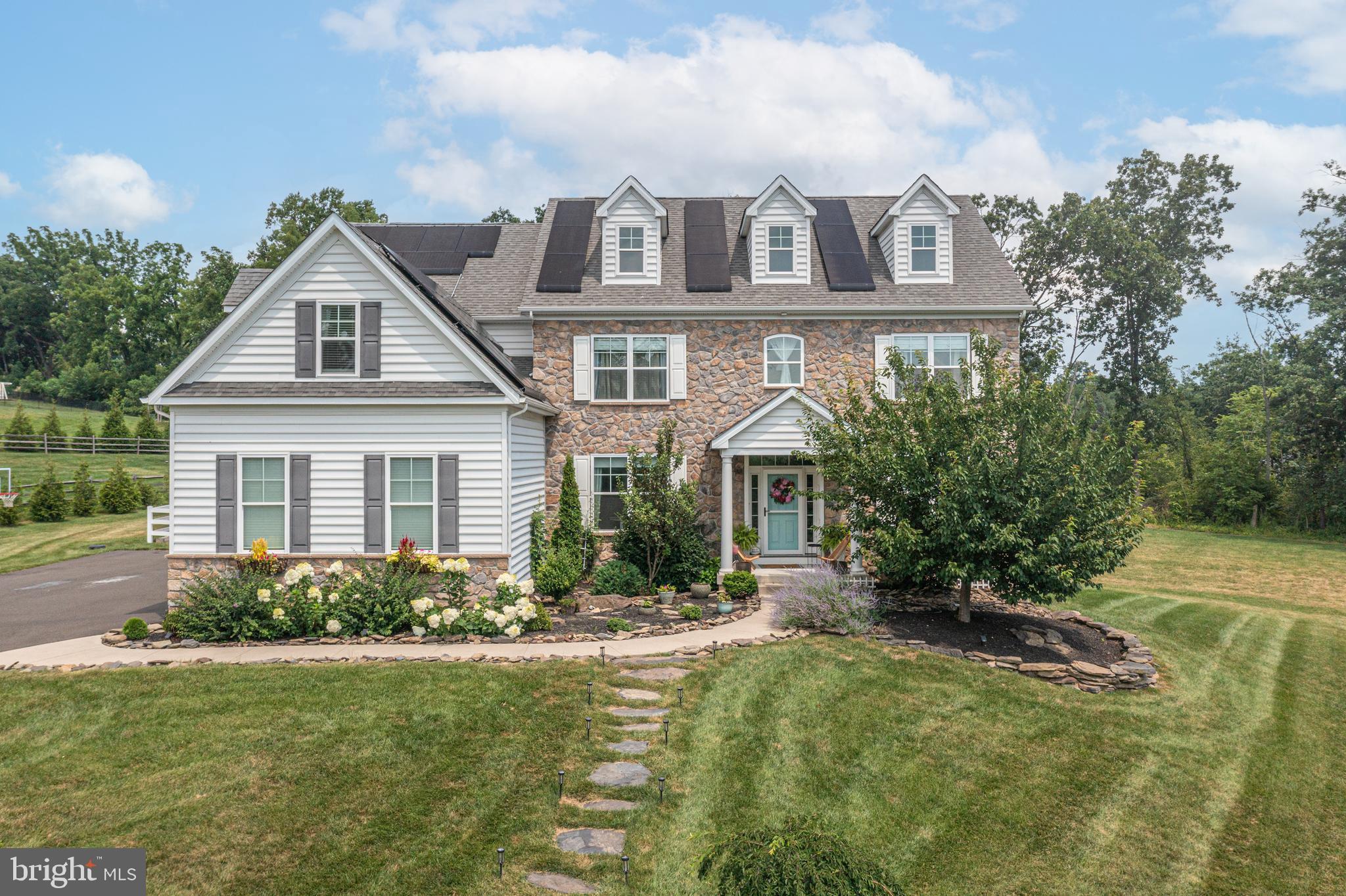 Located just north of Doylestown in the exclusive Owls Nest Farm community, this 3,726 sq. ft. home offers the perfect blend of modern design and classic stone-front charm. Set on over an acre of land, the property’s airy, open feel extends throughout the light-filled interiors.  Inside, the foyer welcomes you with a grand staircase and soaring 9' ceilings. The main level features a home office, mudroom with custom drop zone, and a spacious family room with built-in bookshelves and a custom fireplace. The chef-inspired kitchen boasts a designer Lacanche Cluny french range, gold-tone accents, white quartz countertops, and a walk-in pantry. The layout is perfect for both entertaining and daily living, with a seamless flow into the dining and living areas. The main level also includes a private in-law suite with a sitting room, bedroom, and full bath. Upstairs, the main suite provides a serene retreat with an adjoining sitting room and a luxurious en-suite bath with a freestanding tub. The second bedroom has its own full bath, while the third bedroom features a unique layout with a walk-through closet and access to a fourth hall bath. Additional highlights include a large laundry room, finished basement with over 1,000 sq. ft. of potential space, and a fenced outdoor area with a pergola and raised cedar beds. Ideal for pets, play, or simply enjoying the outdoors, the expansive yard offers endless possibilities. Dual hot water heaters and a whole-home water filtration system enhance convenience.  With sought-after Central Bucks schools and proximity to major routes, this home is a must-see for families seeking space, style, and flexibility.