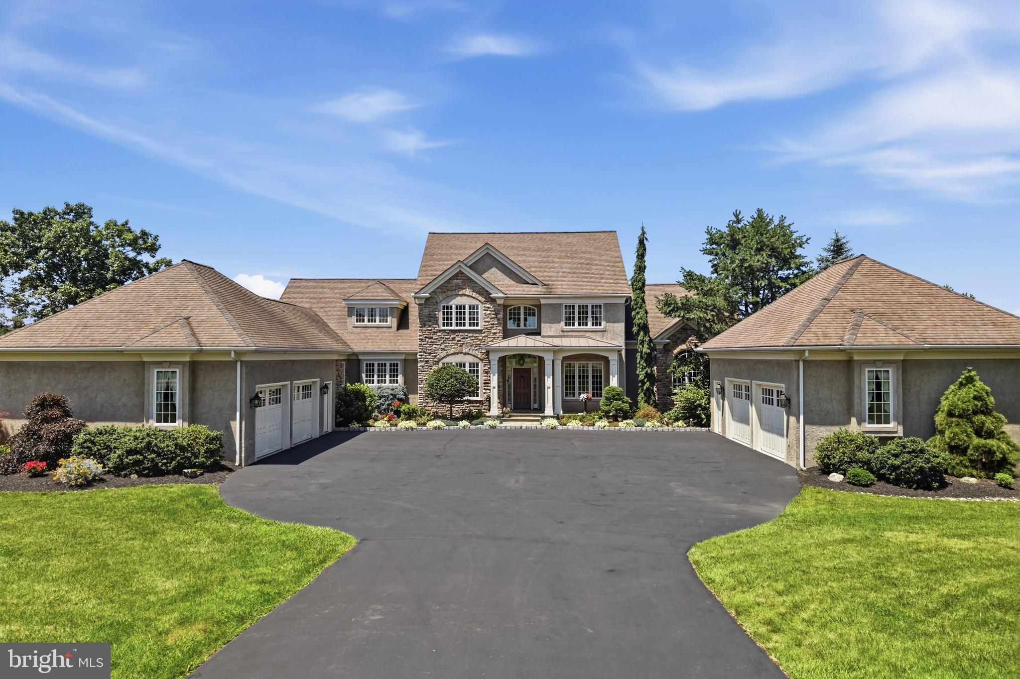 Welcome to 643 Harleysville Pike, Lederach, Pa. This home is for the discriminating buyer who appreciates the countless hours of careful planning and attention to details that went into creating this magnificent home. No detail was overlooked and only the finest materials and craftsmanship were used to complete the home in 2004.
Custom-designed by the original owners in collaboration with architect Michael Curd, and built by custom home builder Tom Kuhar, this five-bedroom, four-and-a-half-bath residence offers approximately 5,229 square feet of living space across three levels.
The exterior makes a strong first impression with its estate-style. It features a broad motor court, and balanced arrangement of the main residence between two substantial garage wings. A mix of textured stucco and cultured stone, layered rooflines, front-facing gables, hipped side roofs, arched details, and a columned ,covered entry give the home a refined character and impressive sense of scale. Professional landscaping, with many specimen plantings , it adds finishing touches to theexceptional curb appeal of the home.
Inside, premium Pella windows bring in abundant natural light. Engineered hardwood floors, detailed millwork, soaring ceilings, open, upper-level balcony overlooks, and two stone fireplaces add warmth and architectural interest.
At the center of the main level is the gourmet kitchen featuring custom- built cherry cabinetry with easy- close drawers , hand-selected granite countertops, stainless-steel appliances which include a five-burner Wolf propane range, double ovens, Bosch dishwasher and a Viking  refrigerator, extensive storage, and a 9’ granite center island with ample seating. Adjacent to the kitchen is a convenient pantry area for dry goods as well as a first-floor laundry area. A set of doors leads to the Travertine patio and adjacent courtyard complete with a soothing fountain.
The kitchen connects  to the wel-lite breakfast area and seperate family room, creating  comfortable spaces for everyday living. 
The first floor also includes a seperate dining room , hardwood floors, nine-foot ceilings with beautiful crown molding. It makes the ideal setting for all your formal entertaining. Directly behind the dining room is a dramatic two-story great room with a breathtaking window wall overlooking the expansive rear yard ,offering natural lighting and a breath-taking view of the northern Montgomery County countryside.  The overall layout provides an ideal balance of connected rooms and clearly defined areas for dining, working, relaxing, and hosting guests.
Directly to the right of the two-story foyer is a den/office. It’s the perfect setting for working at home or just a quiet reading room. It features custom built in shelving and cabinetry.
The first-floor primary suite offers privacy and convenience, with a spacious bedroom with a tray ceiling, a walk-in closet, an expansive en-suite bathroom. The primary bath includes a barrel ceiling, custom cabinetry,and lighting, granite counters, dual vanities, a jetted soaking tub, and a large walk-in glass and tile shower.
The second floor provides of three additional bedrooms and two full bathrooms. One can serve as a guest bedroom and private bath.
The finished walk-out basement expands the home’s versatility with a private in-law suite well suited for extended family, long-term guests, or multigenerational living. The lower level includes a custom designed and crafted kitchen with unique granite tops and ample cabinets, and stainless-steel appliances. It adjoins a welcoming living room with a custom, dry- stacked ,propane fireplace, a large bedroom, full bathroom which features a walk-in jet tub, recreation room,  and additional ,flexible living space.   A Buderas oil heater supplies comfortable radiant heat to the first floor and the second floor baths. .