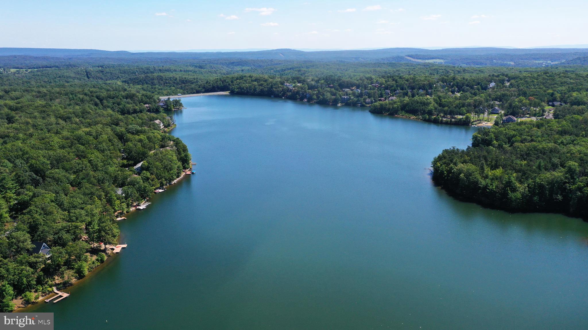 LIVE AT THE LAKE!  BUILD YOUR DREAM HOME ON THIS AFFORDABLE, LEVEL WOODED BUILDING LOT.  In Lake Holiday, a spectacular gated community near Winchester with a 240-acre deep-water lake, mountain views and beaches. Enjoy fishing, boating, swimming, water skiing, a clubhouse with an exercise room, walking trails, dog park, playground and picnic areas, and tennis, basketball and volleyball courts. About 90 minutes from the beltway. An easy drive to historic downtown Winchester, Berkeley Springs and Cacapon State Park. Ideal for full-time living or weekend getaways. Build now with the builder of your choice or hold on to your investment and watch its value grow. No requirement for when you must begin construction. Buyer responsible for $2,000 capitalization fee at settlement. HOA is $144 per month for building lots; $156 for lots with houses.  Water/sewer tap fee currently a total of $5,000. Monthly water/sewer availability fee of $20 until a house is built. Gated community - buyers must be accompanied by their agents. Traffic rules strictly enforced: 25 mph speed limit and complete stop at stop signs.  Green Leaf Drive was formerly known as Forest Drive and appears on plats by its old name. Airbnbs and short-term rentals (less than 6 months) are not permitted.