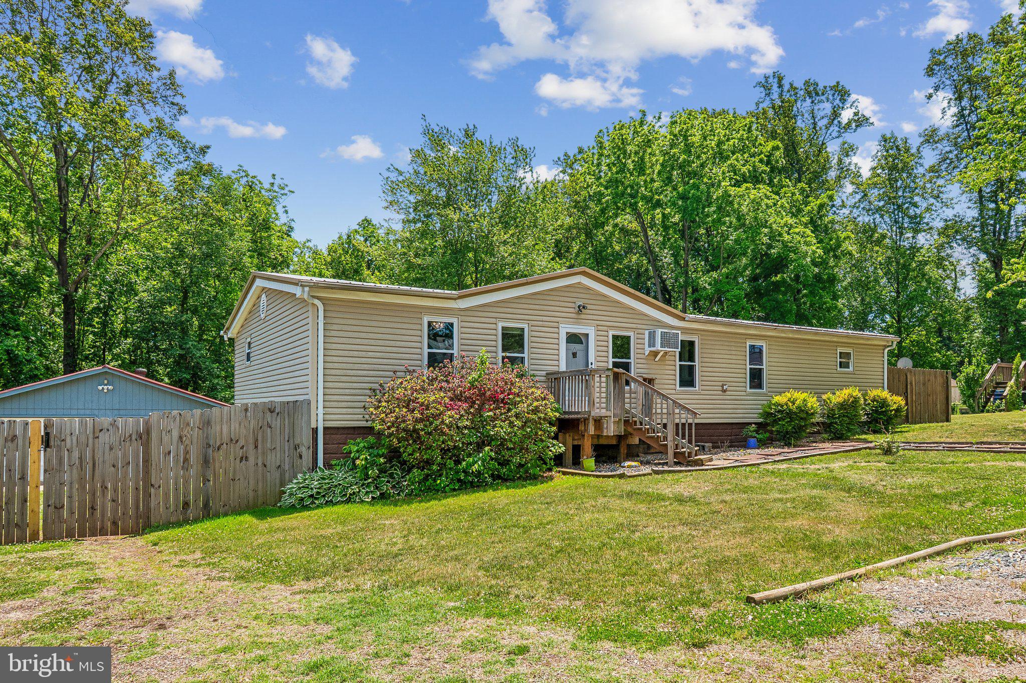 Welcome to 172 Barrett Heights Rd in Stafford, where peaceful country living meets everyday convenience just close enough to Washington, DC for an easy day trip while still offering quiet nights under the stars around the fire pit. This spacious one-level home features 3 bedrooms, 2 full baths, vaulted ceilings, wood flooring, and a bright, functional layout designed for comfortable living and entertaining. The inviting living room is centered around a cozy wood-burning fireplace, while the kitchen offers stainless steel appliances, ample cabinet space, and a casual eat-in area perfect for everyday meals. A separate dining area includes custom built-ins and generous space for hosting gatherings. The primary suite features an updated en-suite bath with double vanities and a beautifully finished glass-enclosed shower, while two additional bedrooms share a hall bath with a tub/shower combination. Outside, enjoy a fully fenced, park-like backyard offering privacy, mature trees, and plenty of room to relax or entertain. A rare combination of a four-car garage, carport, and extensive additional parking provides exceptional flexibility for vehicles, hobbies, or guests. This property offers the perfect blend of comfort, space, and privacy in a serene Stafford setting.