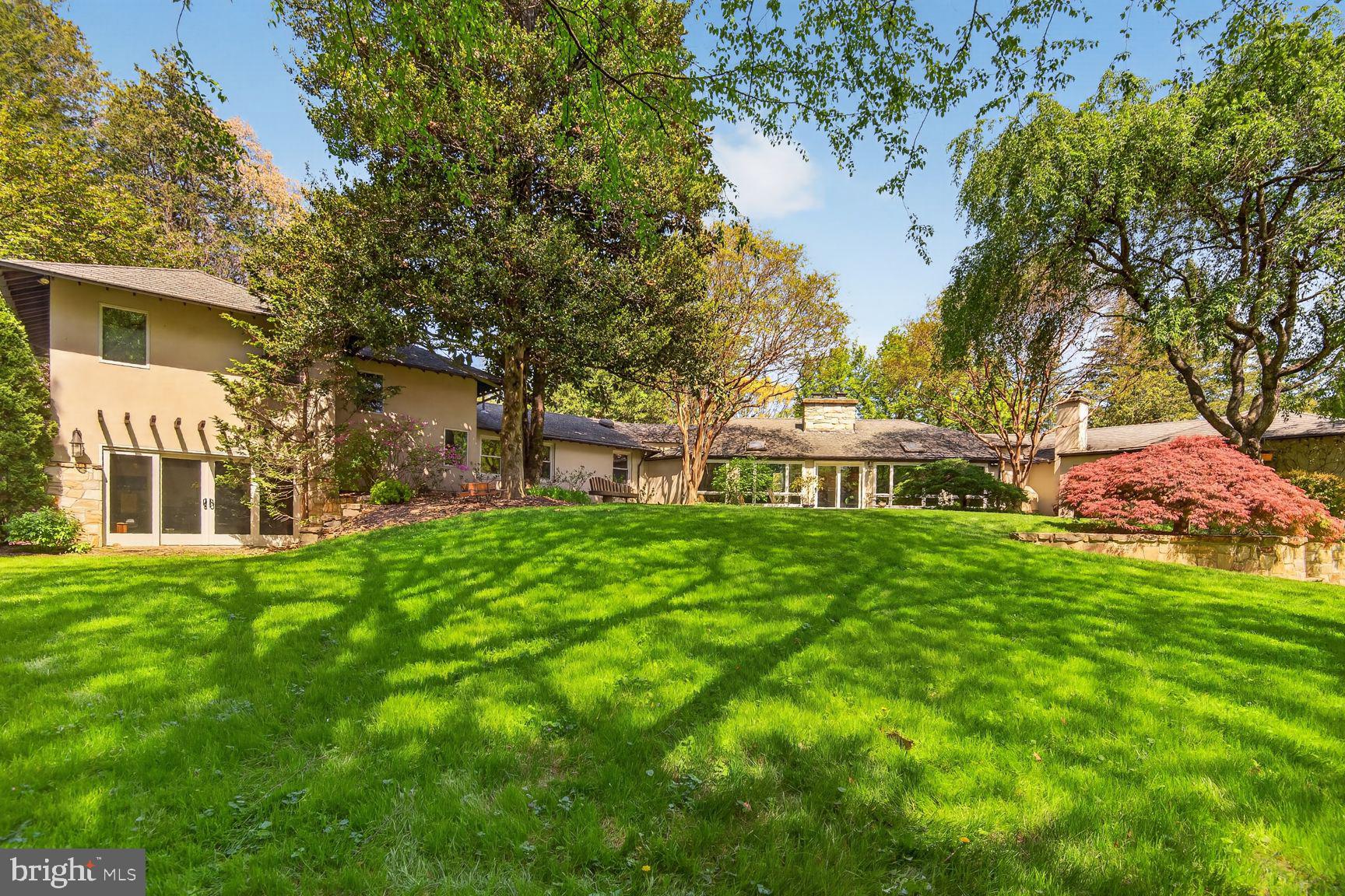 This extraordinary estate home, beautifully sited on over an acre property, is a masterpiece of understated elegance and modern design, unlike anything you've ever seen.  Located inside the Beltway just minutes from The Little City of Falls Church in the highly desirable Malbrook neighborhood, this light-filled mid-century rambler with masterful two-story addition and two car garage was completely renovated and reimagined in 2008 by renowned Old Town architect Robert "Bud" Adams. Primarily one level living with over 4,200 square feet of finished space, the home offers 4-5 bedrooms and 4 full baths with a seamless integration of the full feng shui principles of harmony and balance with classic mid-century modern design: clean lines offset by warm finishes.  Every detail was meticulously crafted including compress and release foyer (an architectural design principle popularized by Frank Lloyd Wright), trim-less plastered walls, stained concrete floors, a wall of patina’d copper and views of nothing but trees from every window. The total renovation down to the studs includes new plumbing, in-floor radiant heating, updated electrical and HVAC, and an architectural shingle 100-year roof.

There are surprises and custom details at every turn. In the living room, the striking copper wall around the fireplace  adds a touch of artistic charm, while the expansive picture window frames the beautiful view of the front yard. Living and entertaining areas include a spacious eat-in kitchen, step down family room, fabulous dining room with custom hearth style fireplace with copper hood and bar area, and additional seating area with magnificent wall of windows overlooking the breathtaking , private backyard. 

The two-story addition includes a dream primary suite and a large home office with incredible views.  There's even unfinished, plumbed space ready for additional laundry or bath, allowing endless possibilities for customization. Whether you're drawn to the masterful design of mid-century modern architecture or the serene natural setting, this home was built to be a sanctuary. The mature trees and professional landscaping on the 1.18-acre property create a peaceful, private retreat just minutes from Washington DC, Arlington, Tysons Corner, The Congressional School, I-66, I-495 and both major airports.
Don’t miss this exceptional opportunity!