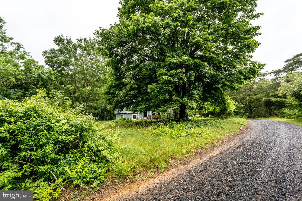 Partially wooded parcel with old cabin/house on the property with well and septic. Mountain views. In the country yet convenient to the towns of Mathias and Broadway. Due to health, the owner had to leave the area with all intentions of returning, but never was able to. The family is selling as is, where is. It will NOT WORK for USDA, FHA or other loans that would go to secondary market. Seller will make no repairs, will not replace windows or remove personal property. County GIS Tax Map is not correct.