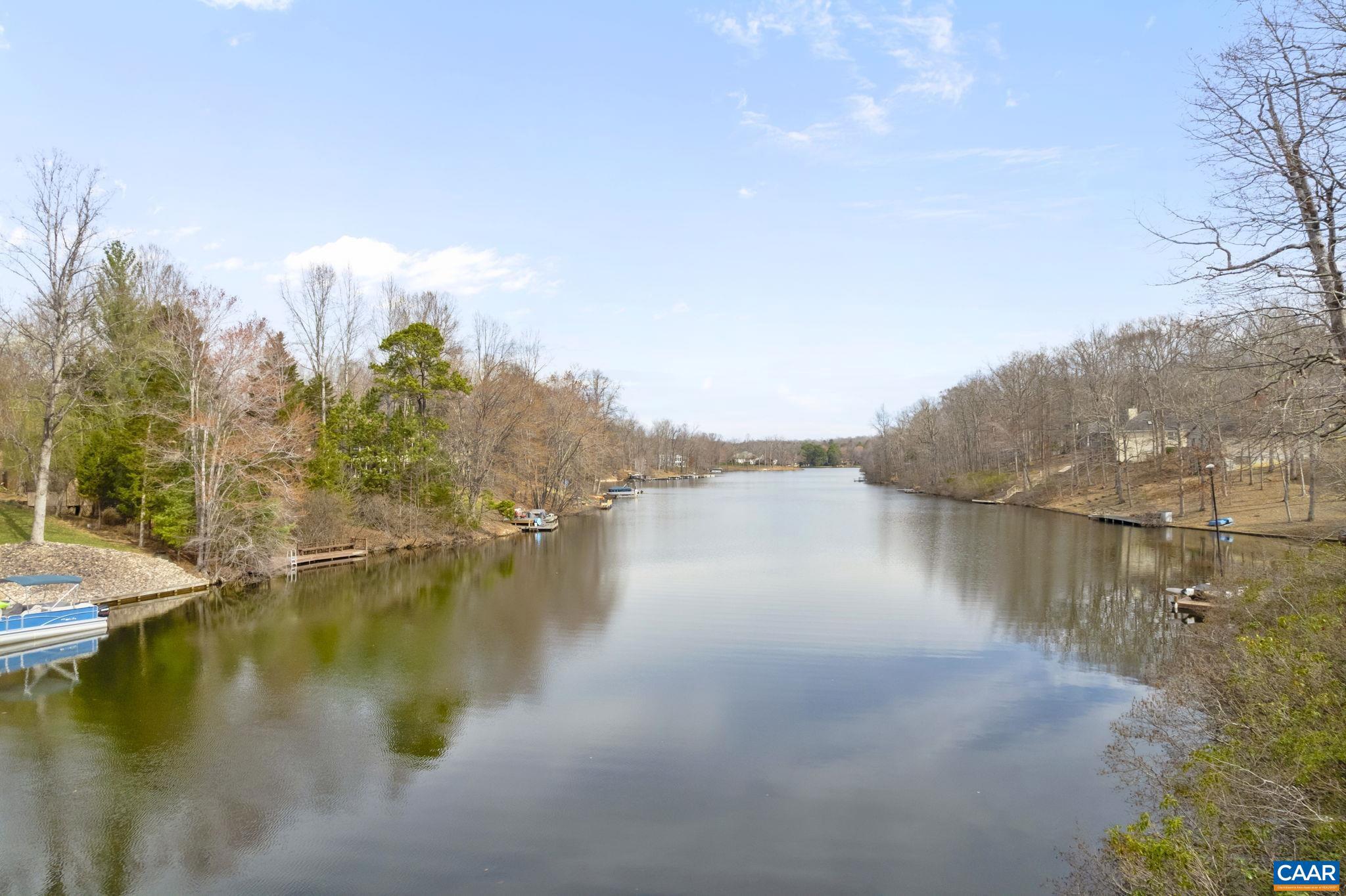 Imagine Beautiful Water views every morning at an affordable price! Privately located, LUXURY LIVING, on a peninsula and offering DEEP water, on Jackson Cove  here at LAKE MONTICELLO. All one level open style living with exceptional views. Upon entering, you are greeted with a formal living room with gas fireplace, cathedral ceilings, large windows and views of Jackson cove. The large eat-in kitchen offers tons of counter space, loads of cabinetry gas stove with electric oven and easy access to the screened in porch. There is also easy access to the formal dining room. A large primary bedroom with tray ceilings, spa like en-suite and morning room or office are also located on the main level along with a second spacious bedroom and full bath. Terrace level includes a large family room with coal burning stove designed to heat the whole house, 1 more bedroom a full bath as well as tons of storage, and the possibility of a 4th bedroom. An OVERSIZED garage, custom built gazebo, with power, and bilevel dock with sitting area, power and boat mooring complete this exceptional offering.  This home is perfect for year round living or weekend/holiday getaways.,White Cabinets,Fireplace in Living Room