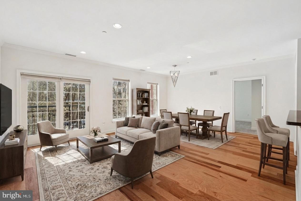Boasting over 1,250 square feet, this pristine two bedroom, two bath residence with PARKING and STORAGE at NAVAL SQUARE features a multitude of upgrades and is not to be missed! Enter into a spacious open floor plan with high ceilings, brand new hardwood flooring, and sliding glass doors leading to a Juliet balcony. The well-appointed granite kitchen features an island breakfast bar, stainless steel appliances, and a pantry, flowing seamlessly into the bright living and dining areas—ideal for both everyday living and entertaining. The desirable split bedroom floor plan ensures privacy for each bedroom. The generously sized primary suite features brand new carpeting, a walk-in closet with custom built-ins, and an en-suite bathroom with a soaking tub, separate glass-enclosed shower, double vanity, and linen storage. The second bedroom is equally versatile and includes a tasteful Murphy bed along with custom closet organization. A full hall bathroom and a convenient side-by-side laundry closet complete this immaculate residence. Amenities of Naval Square include 24- hour security, a state-of-the-art fitness center, seasonal outdoor pool, sundeck, common room, manicured gardens, picnic areas, and guest parking. Situated on a lush 20 acre park-like setting, this pet-friendly residence is just a short distance to fine dining, one-of-a-kind shopping, and world-renowned cultural destinations. DREXEL, CHOP, PENN, University City, Schuylkill River Trail, and Rittenhouse Square are all a short walk away.