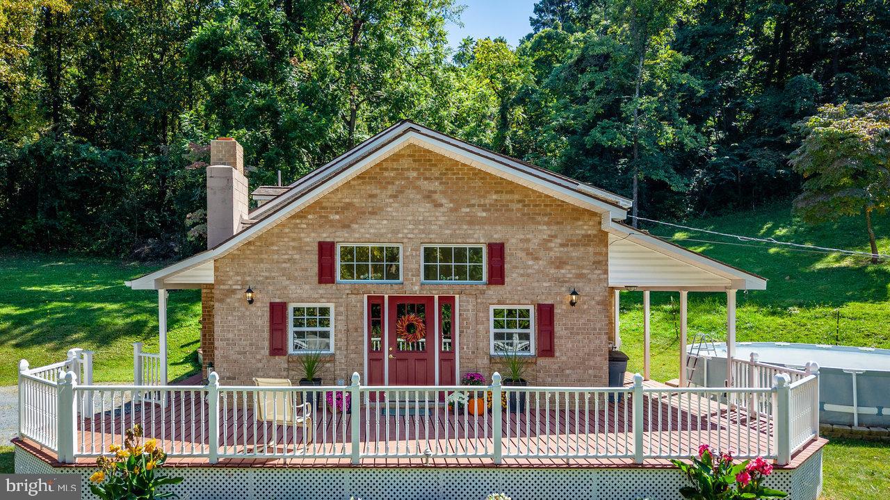 Tucked away in the peaceful setting of Helms Mountain in Stanley, Virginia, this charming cottage offers the perfect retreat for those seeking nature, comfort, and seclusion. Surrounded by towering trees and the gentle sounds of wildlife, the home blends rustic character with modern touches, creating a warm and inviting atmosphere. Inside, you’ll find a cozy living area with vaulted ceilings, and large windows that fill the space with natural light. The kitchen is well-appointed, making it easy to prepare meals after a day of exploring the nearby Shenandoah National Park. Comfortable bedrooms provide restful nights, while the deck invites you to relax with your morning coffee or stargaze under clear mountain skies. Whether you’re unwinding after a long day, or simply enjoying the tranquility of your private setting, this home is a true sanctuary. Don't miss the 18x29 workshop with electric & water, which can accommodate a small vehicle, the partly fenced yard, or the livestock outbuildings.  Perfect for a weekend getaway or extended stay, it offers the rare chance to disconnect and savor the simple beauty of Virginia’s Shenandoah Valley.