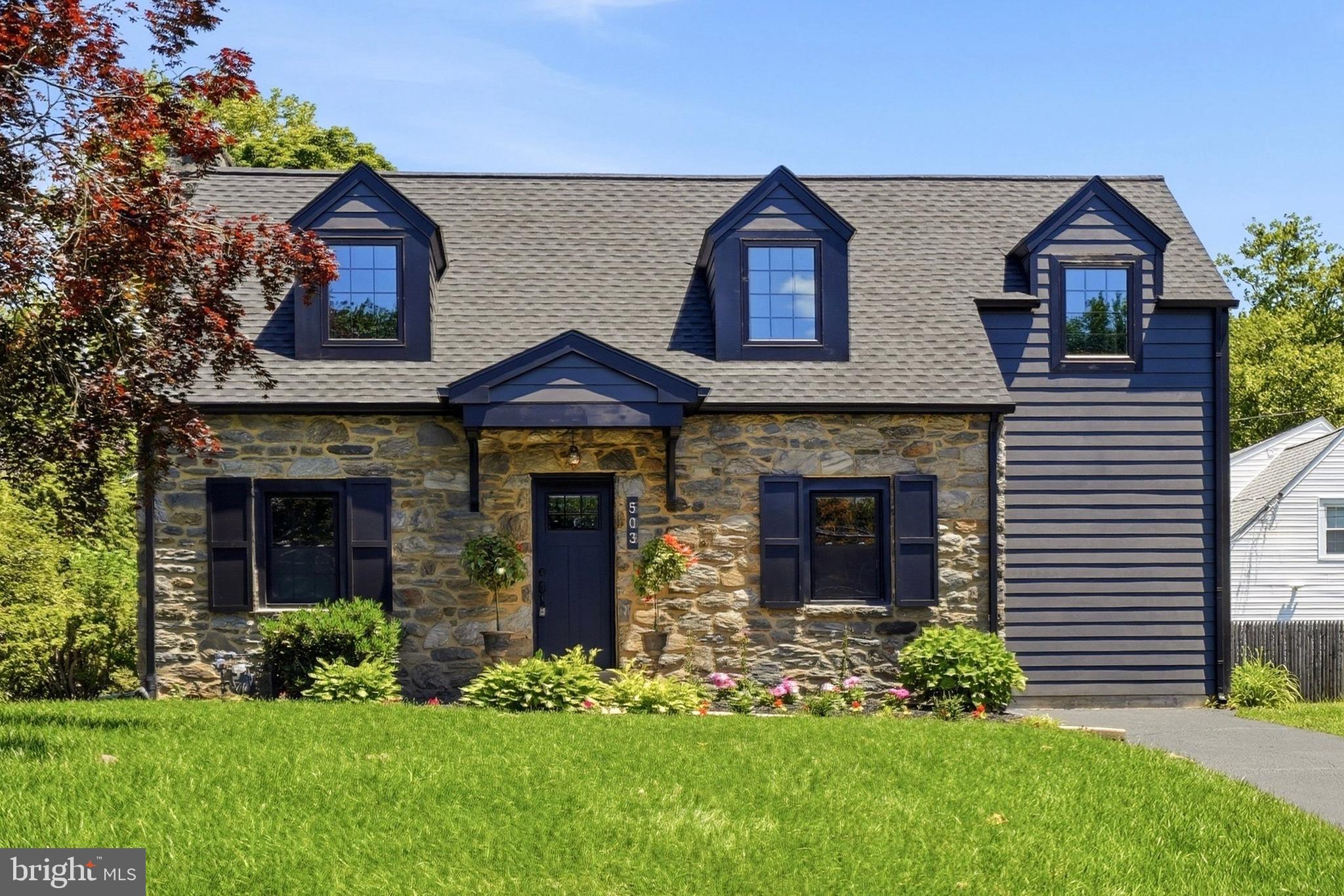 Welcome to this beautifully reimagined cape in the heart of Wynnewood, where timeless architecture meets modern sophistication in one of the Main Line’s most desirable neighborhoods. Thoughtfully renovated and expanded with seamless design and flawless execution, this exceptional property offers over 2,200 square feet of refined living space surrounded by lush landscaping and mature greenery.   Through the looking glass of imagination and innovation, this residence has been transformed while honoring the timeless charm and character of the original home. A calming, sophisticated palette paired with elevated finishes creates an atmosphere that feels both luxurious and welcoming.  The striking stone facade sets the tone for the beautifully curated interiors. Inside, recessed lighting throughout the first floor illuminates the expansive open-concept layout, highlighted by white oak flooring and an oversized living area designed for effortless entertaining and comfortable everyday living.  A private first-floor office accented with chair rail detailing offers the perfect work-from-home retreat, while the stylish powder room features designer tile flooring and contemporary finishes.  At the heart of the home is a sun-drenched gourmet kitchen that is truly an entertainer’s delight. Designed with both beauty and function in mind, the space features flat black stainless-steel appliances, a built-in range with overhead hood, side-by-side refrigerator, dishwasher, illuminated bar, custom cabinetry with mid-century modern hardware, and a dramatic center island with marble top seating. An undermount double brass sink and bespoke tilework elevate the space even further, while sliding glass doors open directly to the patio for seamless indoor-outdoor living.  Upstairs, the primary bedroom suite offers a serene retreat complete with a luxurious private bath featuring a double marble-top vanity, chevron tile detailing, rainforest shower head, and frameless glass enclosure. Two additional bedrooms and a beautifully appointed bath continue the home’s cohesive, elevated aesthetic.  The finished lower level provides flexibility with a full bath and potential for a fourth bedroom, guest suite, fitness studio or additional office space. A dedicated laundry room adds convenience and efficiency to the home’s thoughtful upgrades.  Additional highlights include new roof, windows, electric and plumbing, heating and air conditioning systems, flooring, doors, bathrooms and more.   Situated within the award-winning Lower Merion School District and moments from parks, libraries, shopping, dining and SEPTA Regional Rail, this turnkey residence offers the perfect blend of Main Line elegance and modern living.