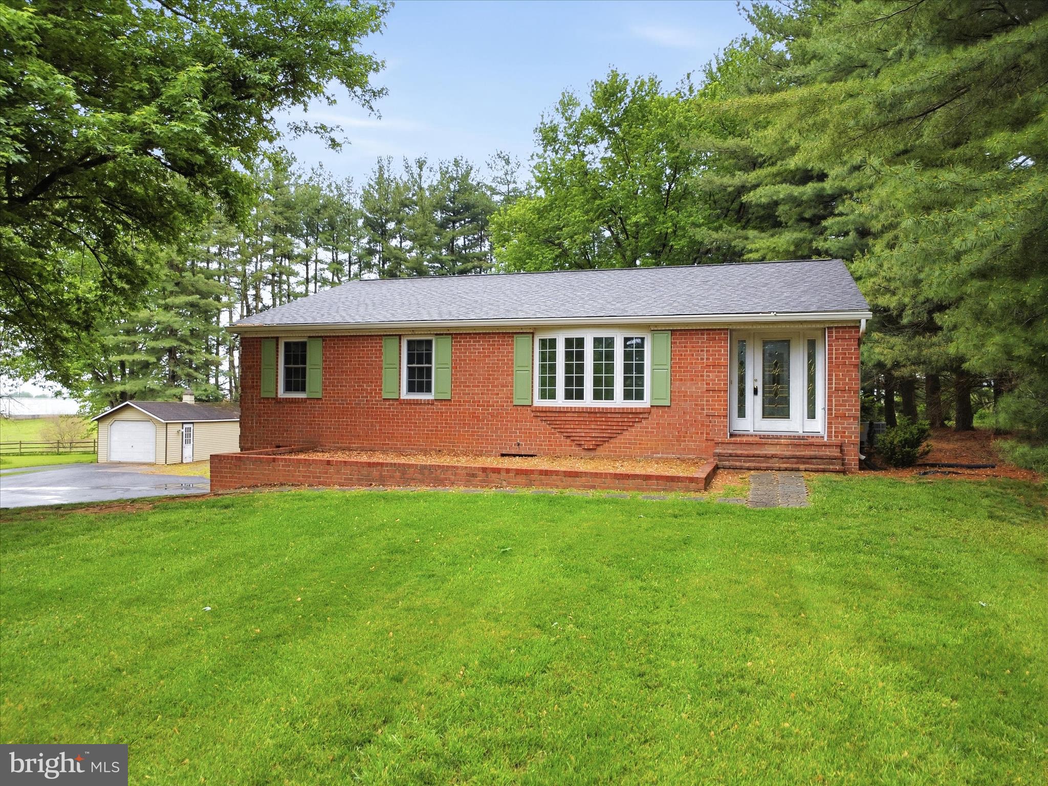 Welcome to the perfect blend of country charm and everyday convenience. This beautifully maintained 3 bedroom, 2.5 bath brick ranch sits on a cleared 0.97-acre lot, offering privacy, space, and scenic views backing to farmland. Originally built in 1983 and offered by the original owner, this home checks all of the boxes. Inside, you’ll find a functional layout featuring a stunning remodeled kitchen (2026), a large dining room, a formal living room, and a versatile space, perfect for a home office or welcoming foyer. The primary suite bathroom includes an updated walk-in shower and a secondary laundry hook-up. Hardwood and carpet flooring (2022) add warmth and comfort throughout. Adding even more options, this home features a thoughtful addition, which includes a bright family room, a convenient second laundry area, a half bath and a separate entry.  This area is ideal for flexible living arrangements or for extra room to entertain or relax. The partially finished lower level offers so many possibilities. This area features flex space perfect for hobbies, living space, storage, or a home gym - there's even a wet bar. An oversized two and a half car garage and baseboard heat, add functionality and convenience.  Comfort and peace of mind are abundant with upgrades including a new roof (2019), updated appliances (within the last few years), a new HVAC system (2025), updated tilt-in windows (2011), and a water treatment system, with a softener and neutralizer. This home is truly move in ready.  Outside, the property truly shines. Enjoy the expansive yard with mature trees along the rear and side boundaries, perfect for watching the wildlife or just enjoying the breeze on the covered back porch. The view through the trees, is like a hidden gem, fields and mountains as far as you can see. This property boasts two large sheds (built in 2000 and 2015) with electricity, a gravel area with RV hookup and abundant parking on the recently repaved driveway (2022). Other notable mentions include a recent well pump upgrade (2022), septic pumping and overall maintenance.  Enjoy the tranquility of country living with the convenience of nearby amenities just a short drive away. This property offers the space, updates, and versatility you’ve been looking for, don’t miss your chance to call it home.