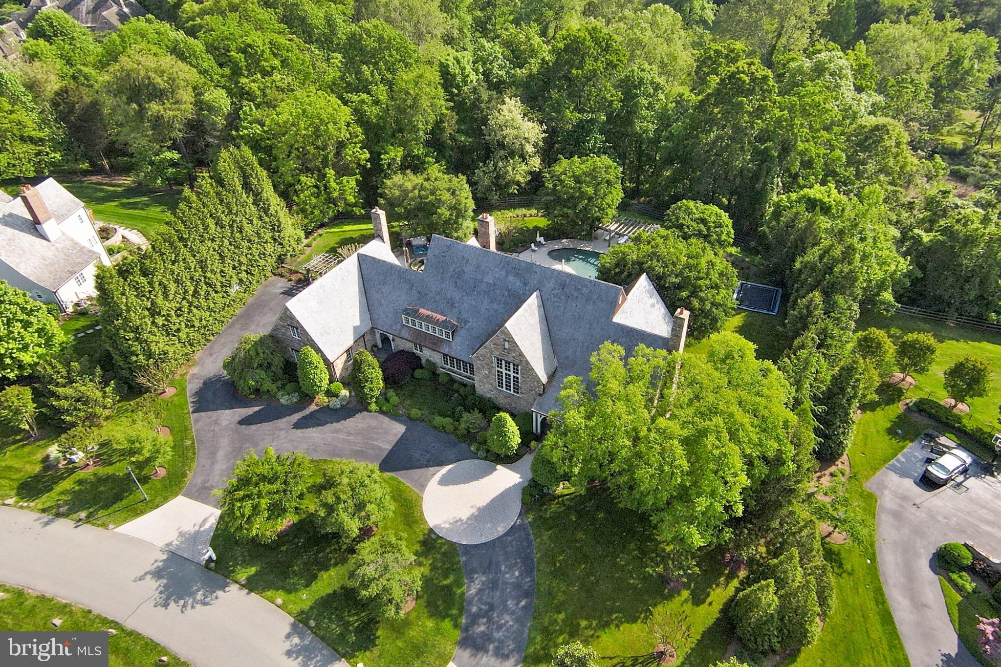 This sensational Stone, English Country Masterpiece built by Brendan O’Neil and designed by Architect David Jones is elegantly sited on a spectacular professionally landscaped 2.79-acre lot featuring panoramic and scenic views! The backyard oasis has won architectural design awards in the Mid-Atlantic! Enjoy the views of rolling hills and mature trees as you sit on the porch that spans the entire back of the house or relax at the saltwater pool with multiple terraces that extend the living space. Also featured are the jacuzzi, built in trampoline with protective netting and built-in stone grill. Gather round the outdoor fireplace at night as you roast marshmallows and sip on wine. Conveniently located inside is a shower, changing area, powder room and washer/dryer.  As you enter the home from one of its two entrances, you will discover extraordinary details with custom millwork, designer materials and expert workmanship throughout. Lush nature and bright light can be seen from almost every room in the house. This home offers tranquility and privacy on one of the most beautiful streets of custom homes in Potomac! The gourmet farmhouse kitchen is perfect for the chef in the family and weeknight meals with a large walk-in pantry, six burner stove, ample beautiful custom cabinets, butler’s pantry with a wine fridge, dishwasher, fridge, and icemaker.  The spectacular great room is sophisticated yet comfortable featuring 16' ceilings and one hundred-year-old reclaimed beams from a Pennsylvania farmhouse that give it a rustic touch. The cozy stone inglenook is ideal for gathering around the fire to sip wine, play games, read, or watch tv! The main level also boasts a den, private office, music room and dining/bar room. The sun drenched second floor includes the private owner's suite with incredible closet space & dressing room, a newly renovated spa inspired luxury bathroom, private veranda, and fireplace. Additionally, a second level family room, guest suite, and three 15' X 15' bedrooms with ensuite bathrooms and laundry room complements the upstairs. The lower-level features multiple work out rooms, a family room, wine cellar, guest suite and full bath. This spectacular Custom English Country home situated in an idyllic oasis is the perfect place to call home and gather with family and friends!