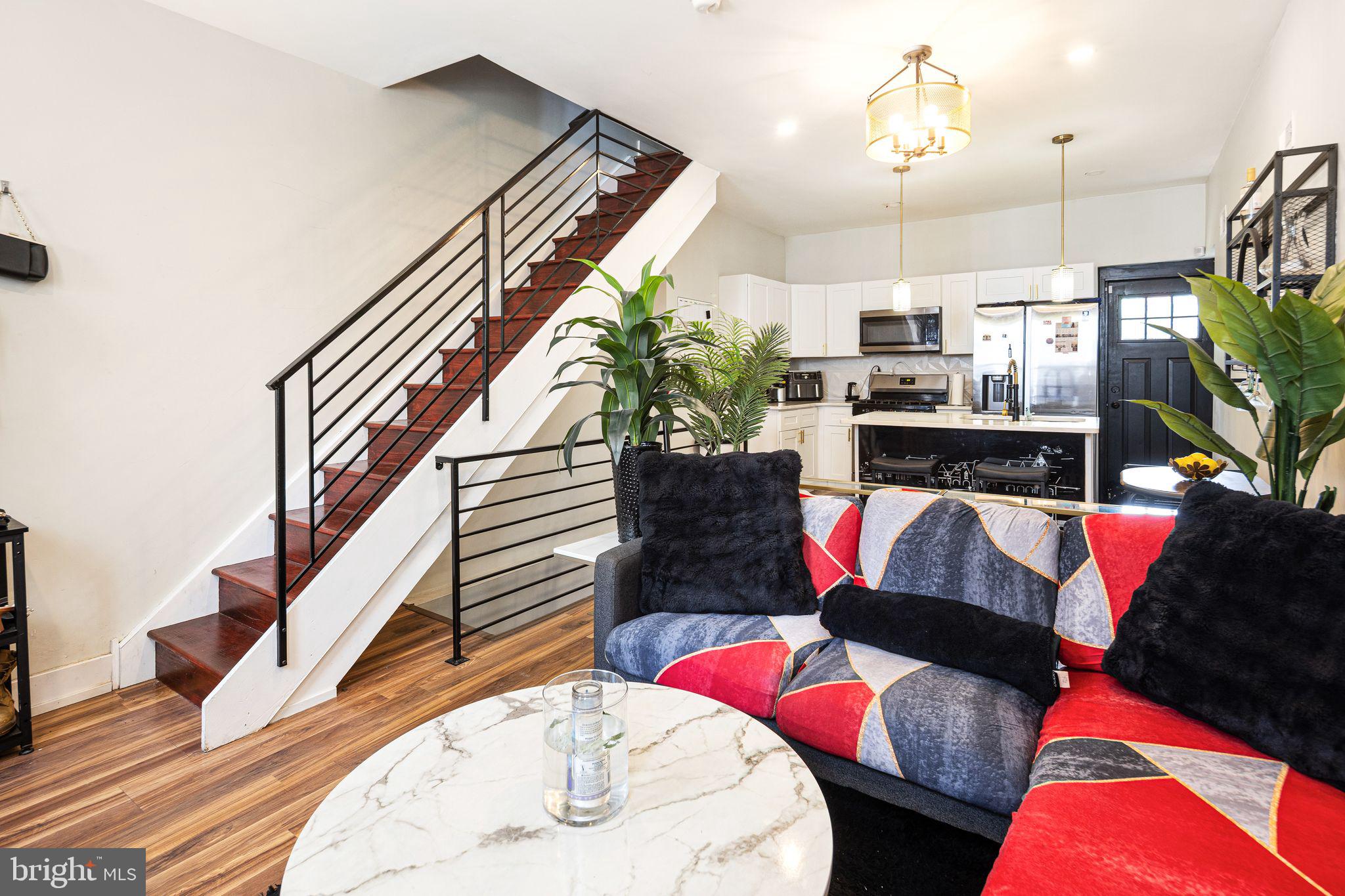Welcome to 1857 N Etting Street, a striking Brewerytown residence offering 2 bedrooms, 2 full baths, and 1 half bath across a thoughtfully laid-out interior with modern finishes and flexible living space. The main level features an open-concept living and dining area with rich flooring, dramatic floating staircase with sleek metal railing, recessed lighting, and a beautifully updated kitchen complete with shaker cabinetry, stainless steel appliances, quartz-style counters, and a center island with seating—perfect for everyday living and entertaining alike. The finished lower level adds valuable bonus space with a half bath, laundry, and room for storage, a home office, gym, or additional lounge area. Upstairs, the bedrooms are well-sized and served by two full baths, including updated finishes and a contemporary feel throughout. Out back, a private fenced patio offers a low-maintenance outdoor retreat ideal for relaxing or dining al fresco. Situated in the heart of Brewerytown, you’ll enjoy close proximity to Girard Avenue dining and neighborhood favorites, plus easy access to Fairmount Park, the Schuylkill River Trail, Girard College, the Philadelphia Museum of Art, and Center City. Offered as-is, this is a great opportunity to own a stylish city home in one of Philadelphia’s most dynamic and fast-growing neighborhoods. Also makes a great investment opportunity, for long-term and short-term renters alike!