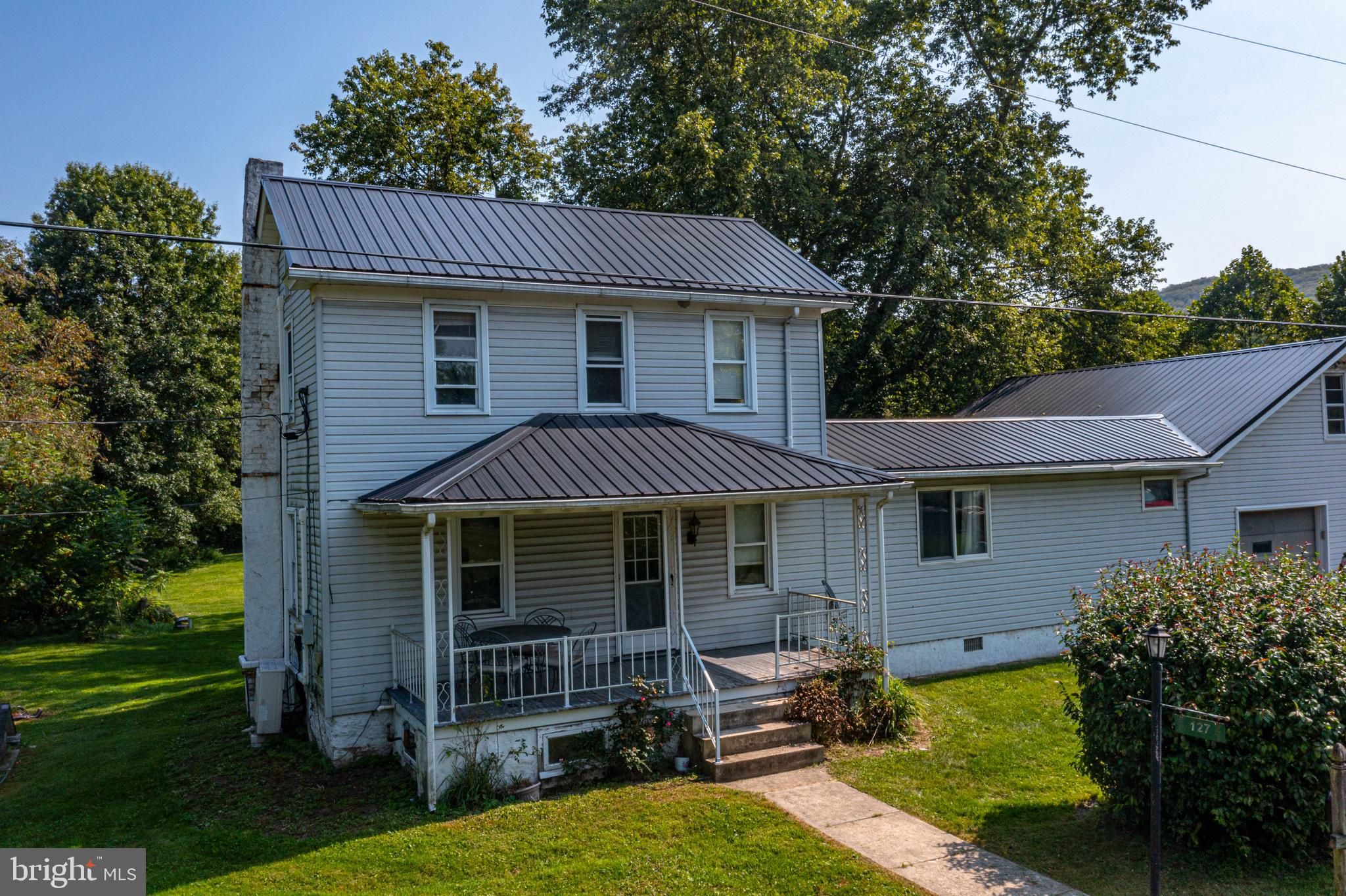 This property features 3 bedrooms and 2 full bathrooms, spread across two stories. Nestled on 1.88 acres in a serene wooded setting, it includes a picturesque creek and a spacious yard. Additionally, there is a pool for leisure and recreation, with convenient access to I-99.