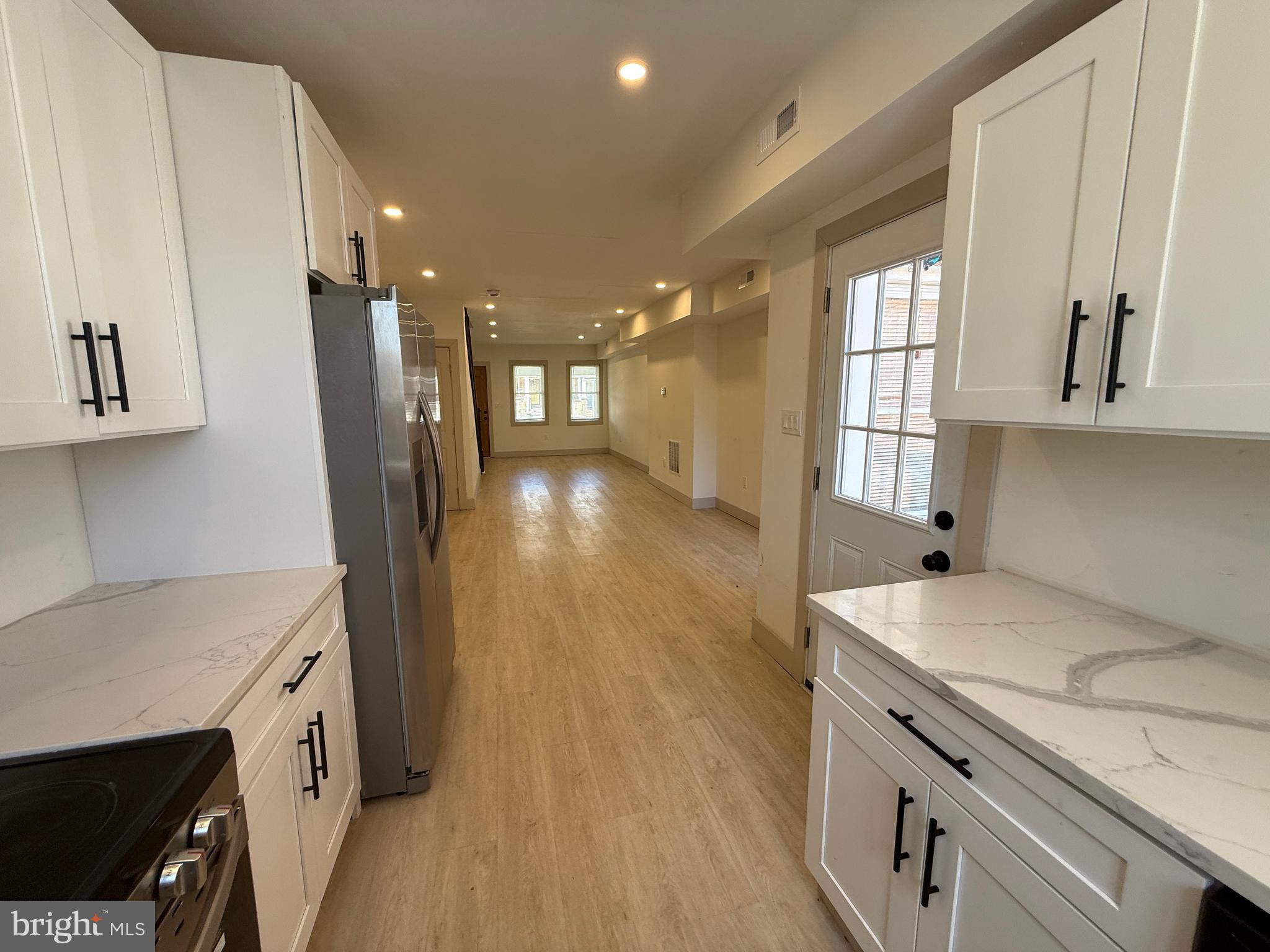 Fully renovated and move-in ready, this stunning Baltimore townhouse blends modern upgrades with functional living space. Featuring 3 spacious bedrooms and 2 full bathrooms, this home offers an open-concept main level with luxury flooring, recessed lighting, and abundant natural light throughout.

The updated kitchen showcases white shaker cabinetry, quartz countertops, stainless steel appliances, and sleek black hardware, creating a clean and contemporary feel. Upstairs, enjoy generously sized bedrooms with ample closet space and a beautifully updated full bath.

The fully finished lower level provides additional living space—perfect for a family room, home office, or guest area—plus a second full bathroom for added convenience.

Step outside to a private rear deck and parking pad, ideal for entertaining or everyday ease. Additional highlights include central HVAC, modern fixtures, and in-unit washer and dryer.

Conveniently located near major commuter routes, shopping, and local amenities—this is a perfect opportunity for homeowners or investors alike.