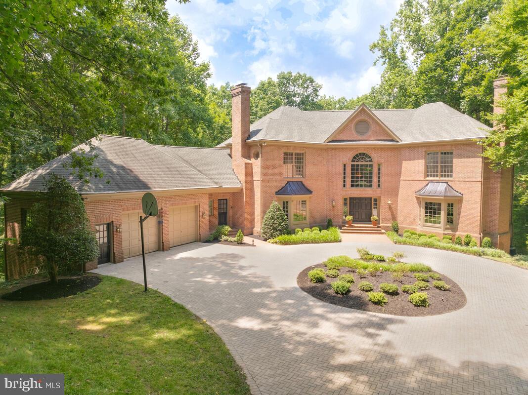 Escape from the world and enter your own modern oasis of spacious tranquility, luxury and ultimate privacy from the moment you approach the elegant gated entrance where trees surround you and the only sound is birds chirping. An iron gate with brick pillars gracefully opens and leads you down the private tree lined drive with landscape lighting. At the end is a stunning paver circular drive and a magnificent 5 bedroom, 5 full and 2 half bath brick Colonial estate! This unique, custom-built home has undergone extensive renovation, with each room updated to offer the latest amenities. It’s a turnkey dream. Expansive windows throughout offer a view of lush woods and reinforce your feeling of natural peace and privacy.  The grand marble tile foyer welcomes you into this extraordinary estate. Quartz counter tops highlight the gourmet kitchen with walk-in pantry, large center cooking island with surround seating, bright, spacious breakfast room and Butler's pantry. Two story ceilings with skylights accent the main level family room with fireplace, giving you the sense of being at home in nature. The formal living and dining rooms both feature beautiful moldings and bow windows. The main level laundry room features a half bath, interior access to the garage and a delivery entrance. The elegant primary suite on the upper level offers a serene and calming setting with propane fireplace, 2 walk-in closets and luxury bath reminiscent of a spa getaway. Opposite the primary is one en-suite bedroom, and two bedrooms that share a Jack and Jill bath and large walk in closets, one being cedar. The lower level is perfect for one who loves to entertain or families seeking spacious and comfortable multigenerational living. A gorgeous built-in full bar offers space for both cocktails and parlor games. A brick fireplace brings warmth to this lower level with gaming area, gym, 2 full bath, bedroom and large room perfect for play or crafts. The lower level opens to a covered patio that leads down to the fenced pool area lush in its surroundings.  The private and secluded backyard oasis surrounds the sparkling inground pool with extensive hardscaping including multiple patio decks. Set on 1.8 acres, this resort-style home has everything you want and more!