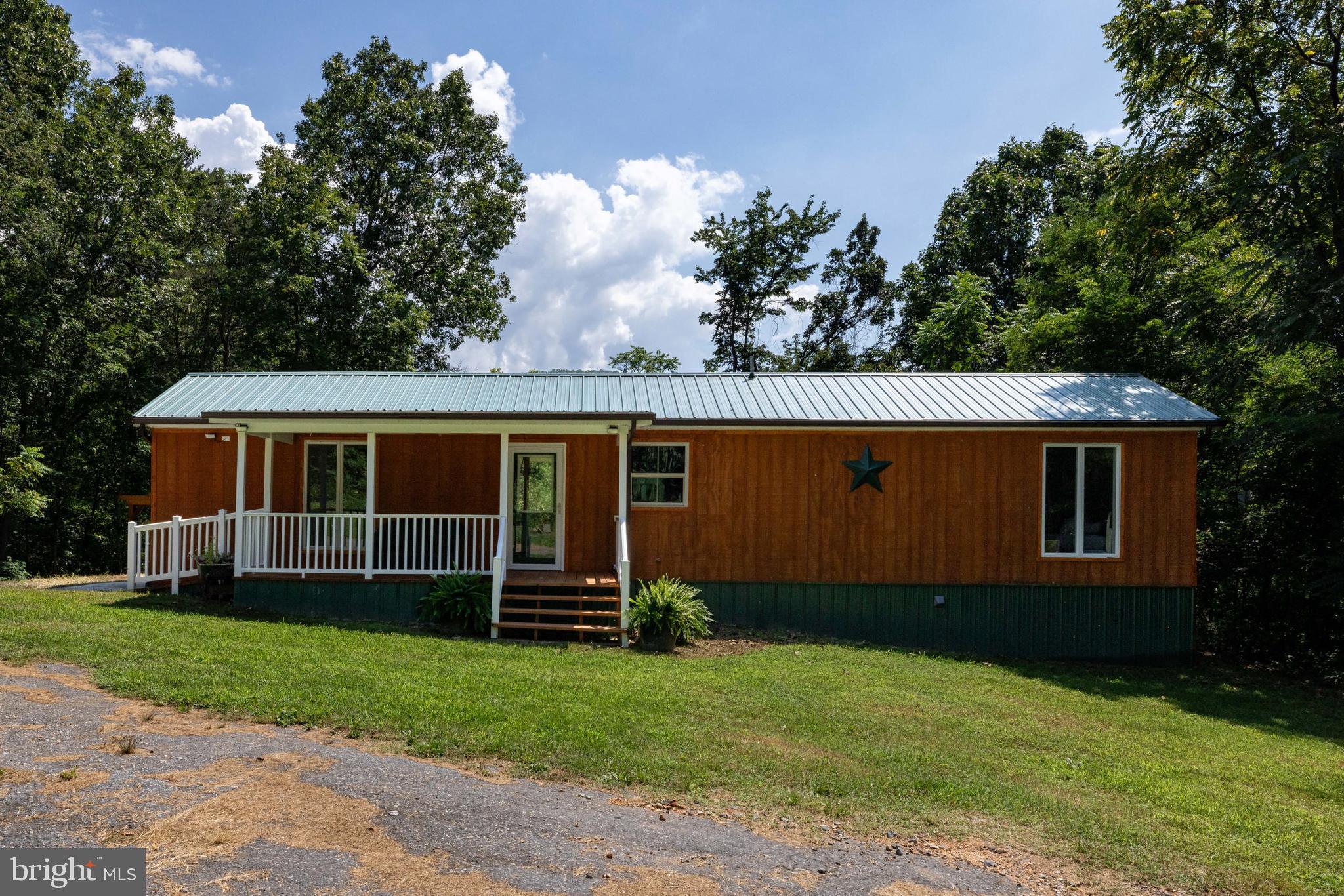 Getaway on Americana! 2 BR 1.5 BA cozy getaway! This property is perched on a knoll in the foothills of the Blue Ridge Mountains! Fully remodeled in 2024, this home is warm and cozy throughout. There is an open kitchen/dining area that flows into a large living room. The large living room is highlighted with beautiful wood walls. Two generous bedrooms are at opposite ends of the home allowing for privacy as you restore yourself with sleep at you getaway in the mountains! Outside, you will find a large covered front and rear porch that allows for many entertaining options. There is also a hot tub off the rear porch to enjoy! Upgrades from 2024 remodel include: new septic system, flooring, windows and porches. Mini splits for heating and cooling provide comfort year round!