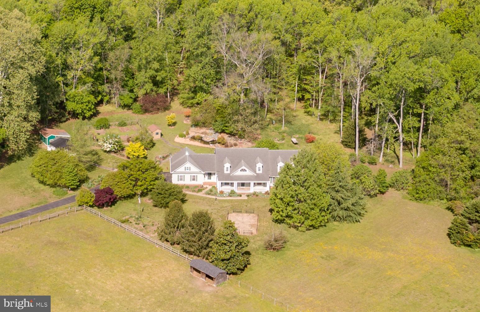 Welcome to a private estate that perfectly blends comfort, craftsmanship, and country elegance—set on 10 serene acres in the coveted waterfront community of Mt. Moriah on the Potomac. Nestled in the back corner of this peaceful enclave, this custom-built, one-owner home offers a rare sense of seclusion and connection to nature, with deeded access to the Potomac River and a neighborhood boat ramp just minutes away. It’s an ideal setting for those who crave privacy without sacrificing convenience to Fredericksburg, Southern Maryland, or Virginia’s Northern Neck.

Spanning more than 4,400 square feet, this thoughtfully designed retreat greets you with an inviting front porch that overlooks manicured grounds and morning sunrises. Inside, light pours through generous windows, illuminating a welcoming foyer and sitting room before leading into an open-concept living area enhanced by a pass-through fireplace—a perfect gathering spot between the expansive kitchen and the comfortable great room. The kitchen itself is a chef’s dream, featuring a large center island, butler’s pantry, and walk-in storage, all accented by views of a decorative pond and surrounding greenery.

Two main-level primary suites offer unmatched versatility, ideally suited for multigenerational living or extended guests, while the upper-level features two additional ensuite bedrooms and a flexible craft or office space. Every detail of this home was designed for ease of living, including a central vacuum system, whole-house generator, and ample storage throughout.

Step outside, and the property truly comes alive. From the large covered porch designed for outdoor dining, to the newly built heated greenhouse and fully equipped chicken coop—this estate celebrates self-sufficient living at its best. Mature trees, blooming garden beds, and a fully fenced vegetable garden surround the home, the handiwork of a master gardener whose care is evident in every detail. Wildlife sightings are frequent, adding to the tranquil charm that makes this property feel like a personal sanctuary.

Beyond the access gate, the Potomac River awaits.  Residents enjoy deeded access to the Potomac and the community boat ramp, ideal for boating, kayaking, or quiet reflection at sunset.

Here, your days can begin with coffee on the porch and end with the peaceful rhythm of nature all around.  This Mt. Moriah retreat is not simply a home—it’s a lifestyle. A secluded farmette where elegance meets authenticity, and where every inch invites you to slow down and savor each day.
