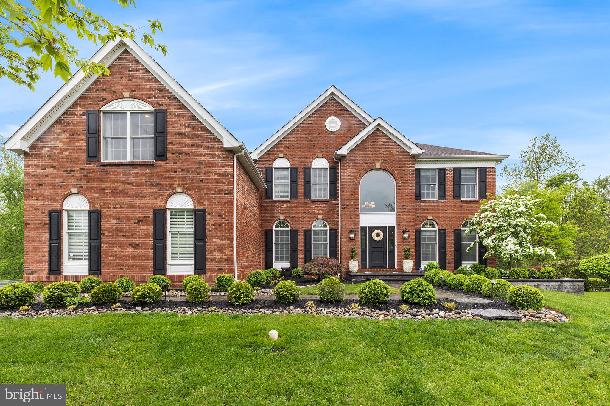Welcome to this stunning brick-front Colonial nestled in sought-after Bridle Estates. Situated on a premium lot backing to serene woods, this exquisite 5 bedroom, 3.5 bath home offers refined luxury and exceptional attention to detail throughout. A timeless paver walkway leads to the new front door, flanked by upgraded exterior lighting. Step into the grand two-story foyer featuring a dramatic turned staircase and gleaming hardwood floors that continue throughout the main living areas. To the left, a stylish home office with French doors provides the perfect work-from-home retreat. To the right, a formal living room—complete with chandelier—offers flexible use as a dining room if desired. The heart of the home is the show-stopping gourmet kitchen, a true chef’s dream. Thoughtfully designed with Mouser inset custom cabinetry, quartz countertops, marble backsplash, and a farmhouse sink, this space is as functional as it is beautiful. The massive 16-foot center island includes two in-island refrigerator drawers.  High-end appliances include a Wolf range, Bosch dishwasher, wall oven and microwave, Sub-Zero refrigerator with pantry surround, and a sleek bar area with beverage fridge and icemaker. A wall of windows fills the space with natural light and overlooks the private, tree-lined backyard. The kitchen flows seamlessly into a spacious dining area and an inviting family room with a floor-to-ceiling stone gas fireplace, plantation shutters, and a convenient rear staircase. A sliding glass door leads to a composite deck, with stairs down to a custom paver patio—perfect for outdoor entertaining. The main level also features a gorgeous powder room, and a functional laundry room with new washer and dryer, utility sink, and access to the 3-car garage (partially converted for storage, but easily reversible). Upstairs, the primary suite boasts beautiful wood floors, dual walk-in cedar closets, and en suite bath with updated fixtures. Four additional bedrooms offer plush carpeting, ceiling fans, and share a nicely updated full hall bath. The stunning lower level provides additional living space, and is beautifully finished with luxury vinyl plank floors, custom built-ins, beverage fridge, recessed lighting, and a daylight push-out casement window that opens as a pass-through to the back patio—ideal for entertaining. A pocket door leads to a spa-inspired full bath with rain shower, and additional spaces include a built-in office with barn doors, a home gym, and a charming under-stair dog house. A full waterproofing system with French drain and dual sump pumps provides peace of mind. Additional highlights include 2 new HVAC systems, new water heater, Newer roof & siding (2012), New garage doors, Electric pet fence around entire perimeter of yard.  This home truly offers the best of elegance, functionality, and comfort in one of the area's most desirable neighborhoods.