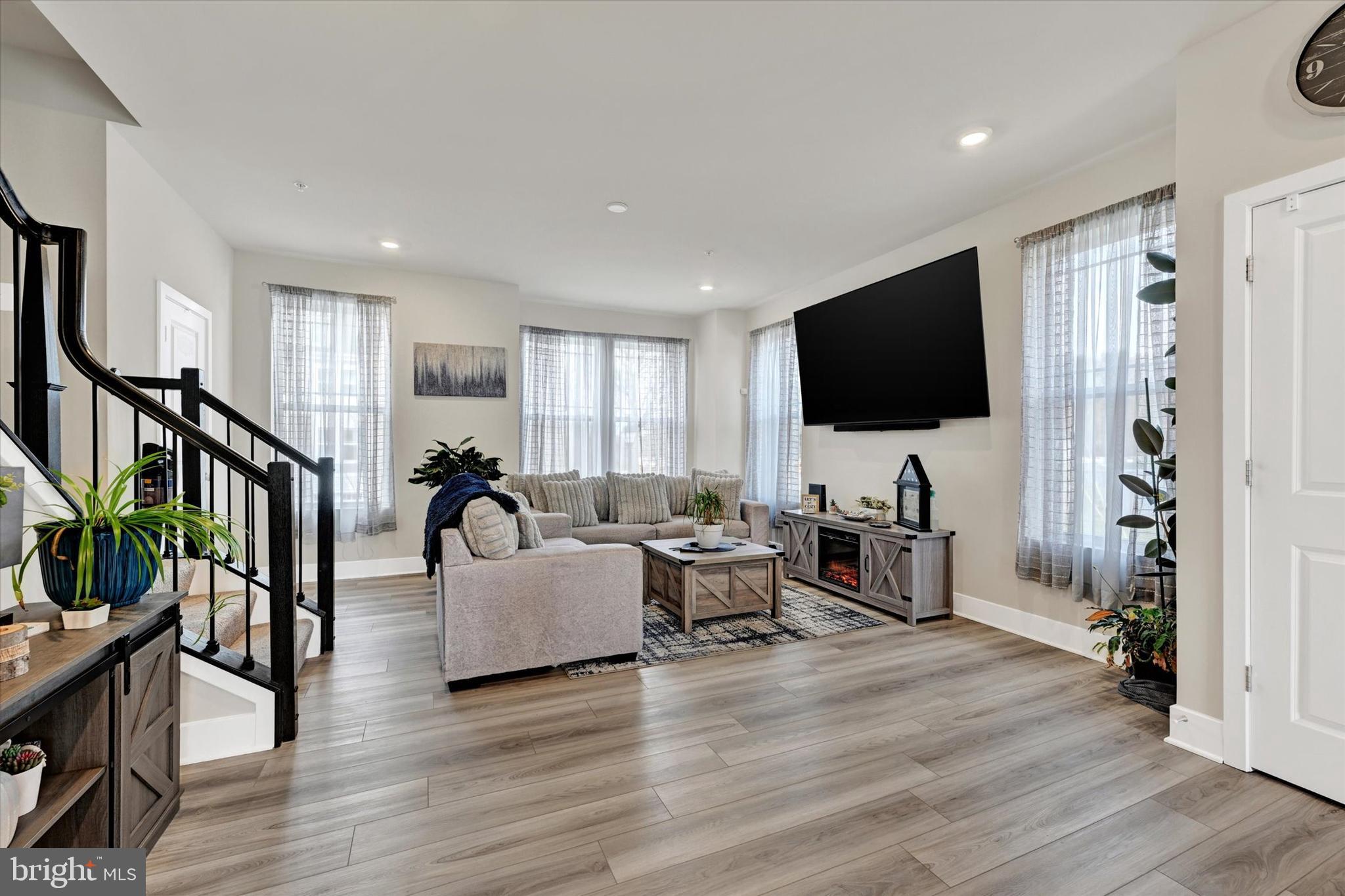 Welcome to your new home in Water’s Landing, an end-unit townhome filled with natural light and a layout that flows comfortably across each level. The entry level offers a flexible space that can be used as a living area, home office, or recreation room, finished with a blend of carpet and LVP flooring and walkout access to the backyard. The main level features an open kitchen, dining, and living area with stainless steel appliances, a spacious island, LVP flooring, a stylish backsplash, and neutral finishes throughout, creating a space that works well for both living and gatherings. Upstairs, comfortable bedrooms and full baths complete the upper level, while a private deck extends the living space outdoors and an attached garage adds convenience. The home is within walking distance to a community dock and pier, offering opportunities for sightseeing. As an added bonus, the seller is including the main-level living room furniture, ottoman, wall-mounted Smart TV, bar stools, buffet table, and window coverings.