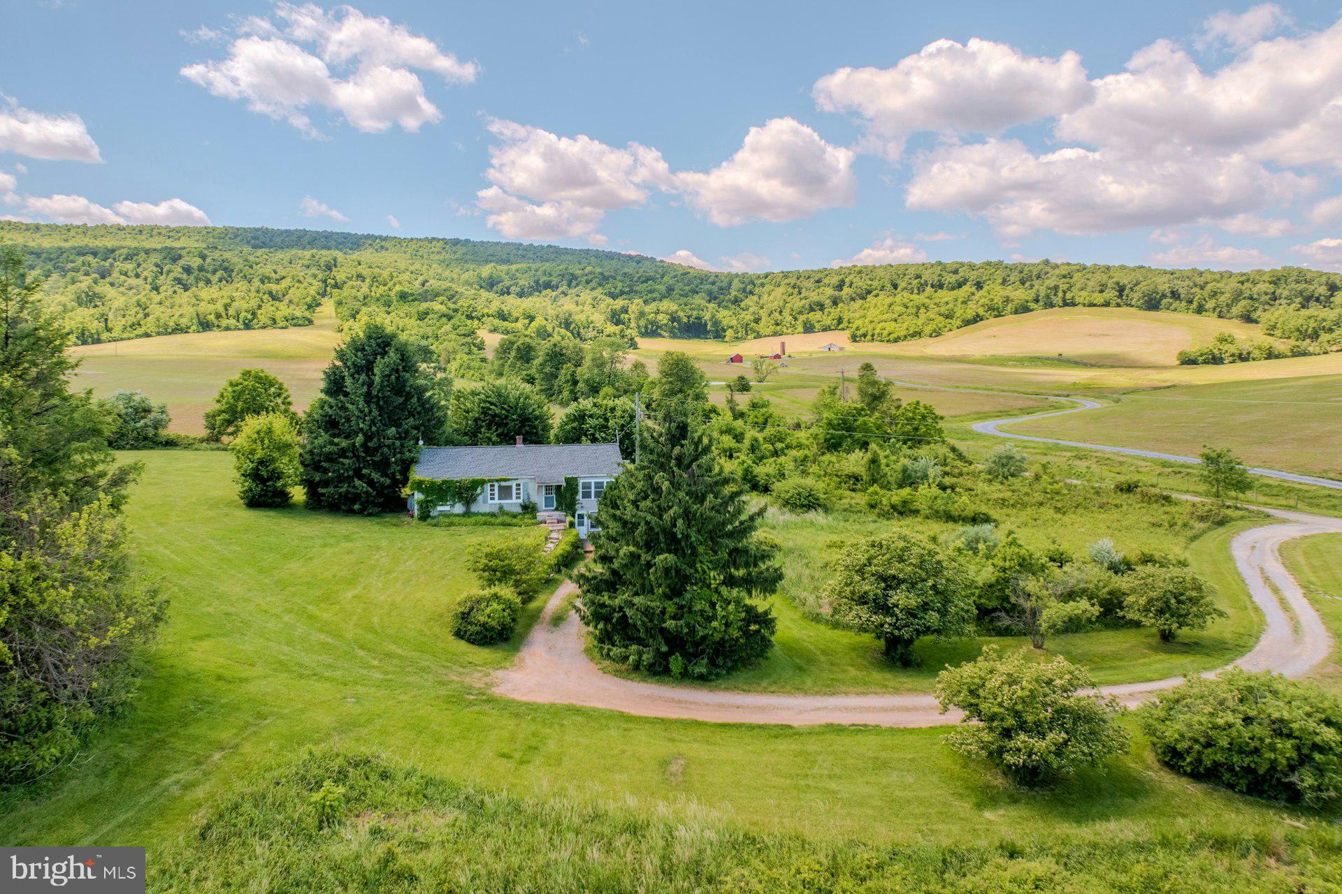 Set on 3.3 scenic acres at the base of the Blackburn Trail Center, this rare property presents a unique opportunity for outdoor enthusiasts, investors, or those seeking a private retreat surrounded by the natural beauty of western Loudoun County. The existing 1,300-square-foot rambler offers 2 bedrooms and 2 baths and is being sold strictly as-is, with much of the value centered in the land and exceptional location. Known as the original tenant house to the historic Hearthstone estate, the property enjoys immediate access to some of the region’s most celebrated hiking terrain, including the famed “Roller Coaster” section of the Appalachian Trail and the breathtaking Raven Rocks overlook. Whether envisioning a rustic weekend escape, future homesite, or investment opportunity, this property offers an extraordinary setting immersed in Virginia’s Hunt Country landscape.
