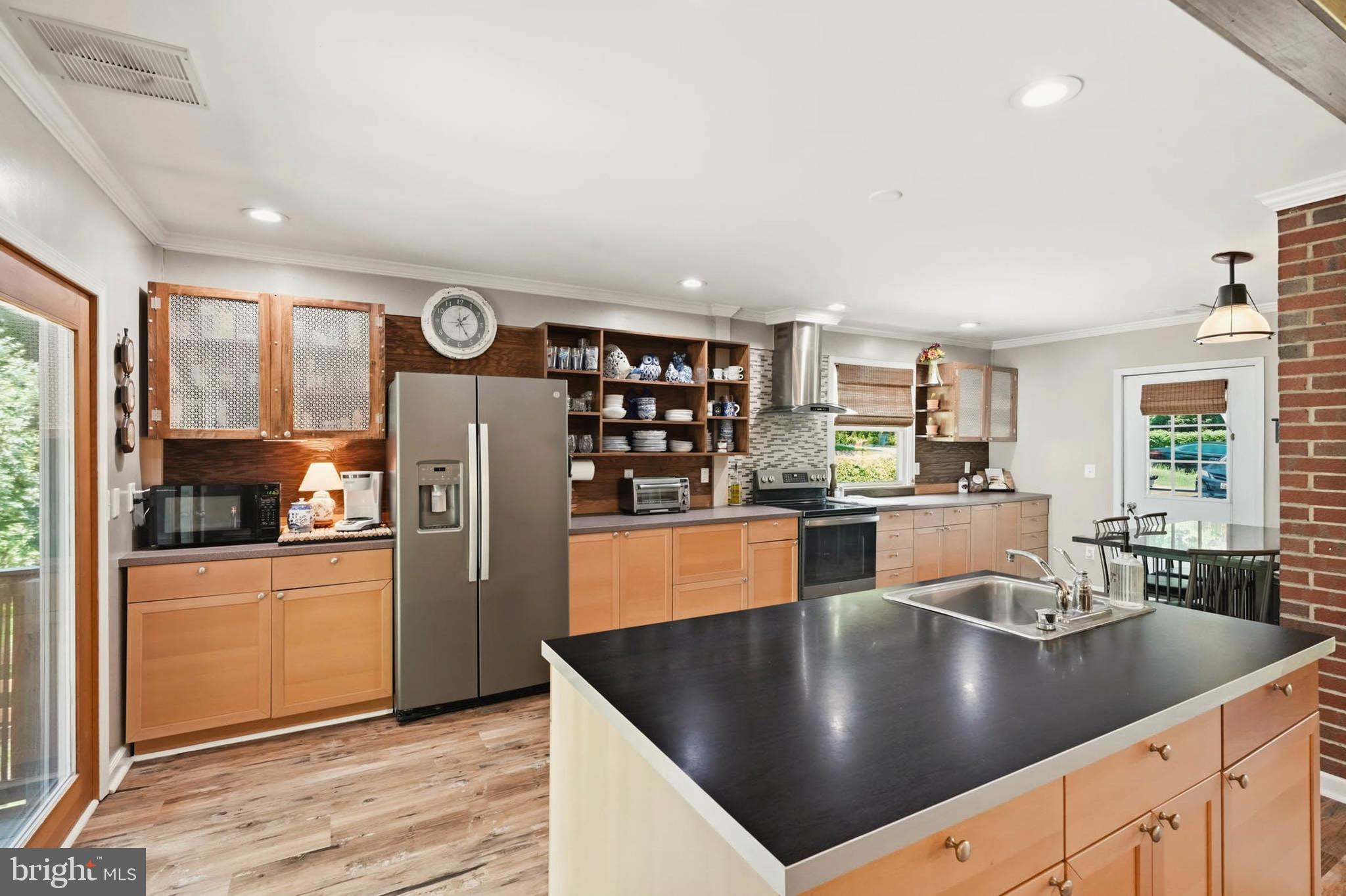 Welcome home! Location, location, location!  Looks can be deceiving, must see inside to appreciate the open, airy, light filled space. 

This home is located in the highly desirable Hillsmere Shores community, offering a private beach, community pool, marina, and multiple launch areas for boats, kayaks, canoes, and paddleboards — the perfect setting for anyone who loves life on the water. The home features four spacious bedrooms and three full baths, all set within an open, airy floor plan designed to capture natural light and create an inviting sense of space. A generously sized kitchen serves as the heart of the home, offering abundant prep areas, modern appliances, and effortless flow into the main living spaces. The living room is anchored by a refined propane fireplace, adding warmth and ambiance throughout the seasons.

The lower-level functions as an extension of the home, complete with a private bedroom and full bath—ideal for guests or multigenerational living. A sprawling great room provides endless possibilities for entertaining or relaxation, while a dedicated laundry space and two additional flex rooms offer versatility for a home gym, office, studio, or hobby space. Bring your vision and ideas to make this space your own.

Sitting on a generous lot, the property backs directly to Quiet Waters Park and includes a private path for easy access and all the park has to offer...hiking trails, a playground, dog park, outdoor summer concerts and several other fun events throughout the year.  The fully fenced backyard is designed for entertaining, complete with a bar area and firepit for evenings outdoors. The detached garage/barn provides endless possibilities — workshop, studio, storage, or more.

A massive, fully covered deck spans the back of the home, creating an ideal space for crab feasts, cookouts, or simply relaxing and enjoying the peaceful surroundings.

This home is truly a must‑see. Looks can be deceiving — it is far more spacious than it appears from the outside, offering room to spread out and enjoy every part of the property and its incredible location.