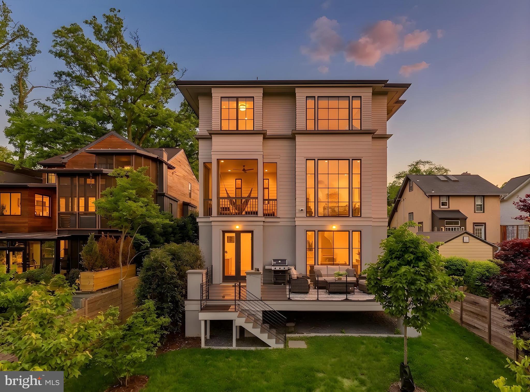 There is new construction in Lyon Park — but there is nothing quite like this.
From the moment you step through the front door, 135 N Edgewood announces itself. A gracious entry foyer opens into a beautiful hallway that draws your eye all the way to the back of the home, where floor to ceiling windows pour light through the entire main level the kind of first impression that stops you mid-step. This is not a house that reveals itself slowly. It lets you see exactly what it is, right away.
The main level is both elegant and livable in equal measure. A dedicated office or flex room sits just off the entry, quietly tucked, completely functional. A powder room. And then the formal dining room, anchored by a designer light fixture that makes the space feel considered and special without taking itself too seriously. Beyond that, the home opens fully: a chef’s kitchen flowing into an everyday dining area and a generous family room, all of it connected and light-filled, designed for the way life actually moves. Off the back, a screened porch perches above the yard - an elevated, beautifully finished outdoor room that blurs the line between inside and out in the best possible way. On a warm evening, with the doors open and the light fading, there is truly nowhere else you would rather be.
Upstairs -Light floods the upper level, where a beautifully appointed lounge area greets you, a natural gathering space that anchors the floor before the bedroom wing unfolds. Three secondary bedrooms, each with its own ensuite bath, feature the kind of tile and finish selections that feel custom & considered rather than off-the-shelf - soaking tubs, unique tilework, fixtures chosen with a real point of view. And then the primary suite, which is genuinely in a league of its own. Walls of windows, extraordinary light, a massive walk-in shower, a freestanding soaking tub, a double vanity, and two closets wrapped in finishes that make the room feel like a destination rather than just a place to sleep.
The lower level at grade, bright, and fully open to the outdoors, it functions as a complete extension of the home-  a large family room and entertaining area, a fifth bedroom, and a full bath, all flowing out to an expansive deck and a backyard that simply keeps going. Beyond the property line sits a private neighborhood park, adding a layer of open green space and natural beauty that no amount of landscaping can replicate. It is the kind of backdrop that makes you exhale every time you look at it.
A garage plus a driveway that handles multiple cars with ease. And tucked privately away, a fully separate home office and workout space with its own powder room and its own entrance. For anyone who works from home, runs a business, or simply values the ability to close a door between work and life, this space is a genuine differentiator. It offers the autonomy of an entirely separate suite without ever leaving the property.
Lyon Park itself deserves a word. This is one of Arlington’s most beloved and established neighborhoods:  walkable, connected, and rich with the kind of community energy that makes people move here and never want to leave. Clarendon’s celebrated dining, shopping, and nightlife are minutes away on foot. Commuter routes and Metro access make the broader DMV effortless to navigate. And the neighborhood itself - tree-lined, architecturally rich, genuinely walkable provides the kind of daily quality of life that is increasingly hard to find this close to the city.
Custom construction with finishes that have to be experienced in person to be fully appreciated.
There is new construction in Lyon Park. And then there is this.