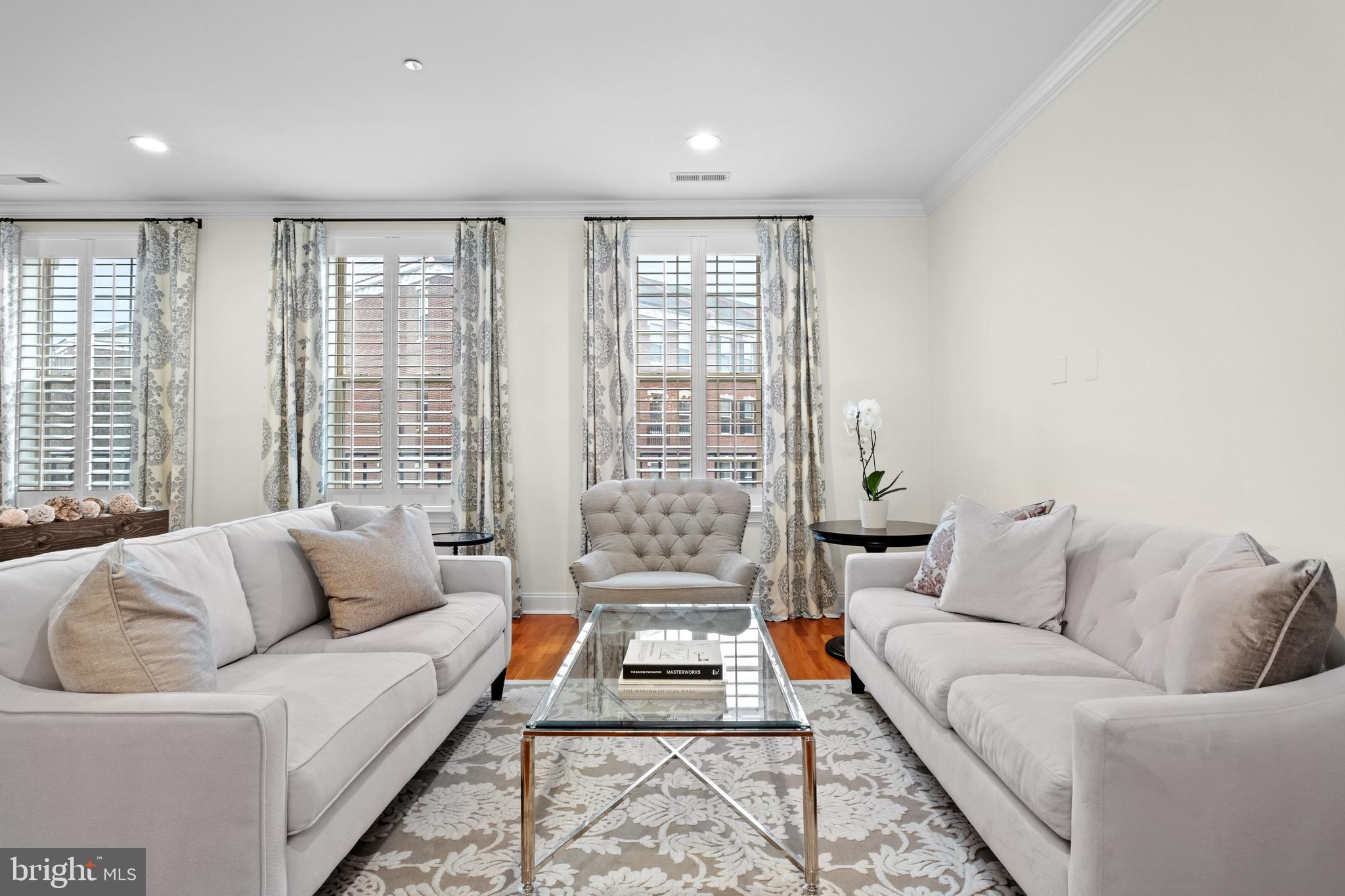 Introducing a magnificent townhome that encapsulates luxury living in the heart of Philadelphia!  Ideally located in a prized, gated enclave just south of Fitler Square, and only steps to University City, this Naval Square home is exactly what you have been waiting for! 708 Captains Way is an exquisite bi-level townhome boasting 4 bedrooms, 2 full baths, 2 half baths and a deeded parking space! As you step inside this pristine home, you'll immediately notice the care and dedication the owners have put into both updating and maintaining this lovely home. The location of 708 is prime— uniquely positioned and nonadjacent to other townhome buildings — this home offers unmatched privacy and seclusion, in addition to affording it an abundance of natural light! On the first level, you will be welcomed into a spacious open concept living/dining area with gorgeous cherry hardwood flooring, freshly painted walls and upgraded recessed lighting. Next, flow seamlessly into the well designed kitchen with professionally refinished white shaker-style cabinets, stainless appliance suite, including an LG Counter depth French door refrigerator. Tumbled marble tiled backsplash & sleek granite counters and large pantry complete the space. An adjacent, more casual eat-in-kitchen area is the perfect space to enjoy your morning coffee. The adjoining family room is full of sunshine, and opens to a private terrace spanning the full length of the property. The spacious terrace embraces beautiful treetop views and a stunning vantage of the nearby Roberts Center. On the second level, you will find an elegant primary suite with vaulted ceilings, upgraded hardwood flooring, and a luxurious walk-in-closet, completely outfitted with gorgeous custom built-ins by Closets by Design. Luxe ensuite bath features upgraded dual sinks, granite tops, soaking tub & separate shower with frameless glass enclosure. On this level, you will also find two additional sunlit bedrooms, full bath, and laundry closet with built-in cabinets and a newer side-by-side LG washer & dryer (2024).  Just when you think you have seen it all- there is an entire additional level! The recently finished basement boasts a 4th bedroom with a large window, PLUS a nice sized den/ study and a beautiful 2nd half bath. Tucked away under the stairs you will find TWO spacious storage closets with practical storage solutions.  Enjoy neutral paint, newly carpeted stairs to the basement, upgraded light fixtures & bathroom hardware, and beautiful plantation shutters throughout the entire home.  Have peace of mind knowing that the hot water heater was replaced in 2021 and there are two HVAC units (lower unit is original and upper unit was replaced in 2022). Smart home features include: one Nest thermostat. Deeded pull-in parking space (700 Captains Way Unit #P359) is just steps from the home. 
Enjoy the ease of having the pool & state-of-the-art fitness center less than a minute walk from your building and the concierge close by. The dramatic community room in Biddle Hall rotunda is perfect to reserve for private parties. Enjoy the outdoor amenities of the 20-acre park-like setting: including picnic areas, well-kept gardens & mature landscaping. With a gated entry and on-site visitor parking, convenience and security are paramount. Very close proximity to South Street Bridge, UPenn (0.7 mi), CHOP, HUP & Drexel, Rittenhouse (0.9 mi) & Fitler Square. Fantastic restaurants and cafes, such as Rival Bros Coffee, Friday Saturday Sunday (James Beard Winner), Illata BYOB, Pub & Kitchen, Southgate, Sabrina's & Loco Pez, are all just steps outside the gates. The new Heirloom Market by Giant and South Square Market are only a block away. Directly out the back gate you will find easy access to the Schuylkill River Park, including the Award Winning Trail & Boardwalk, Markward playground, Tennis Courts & dog park!