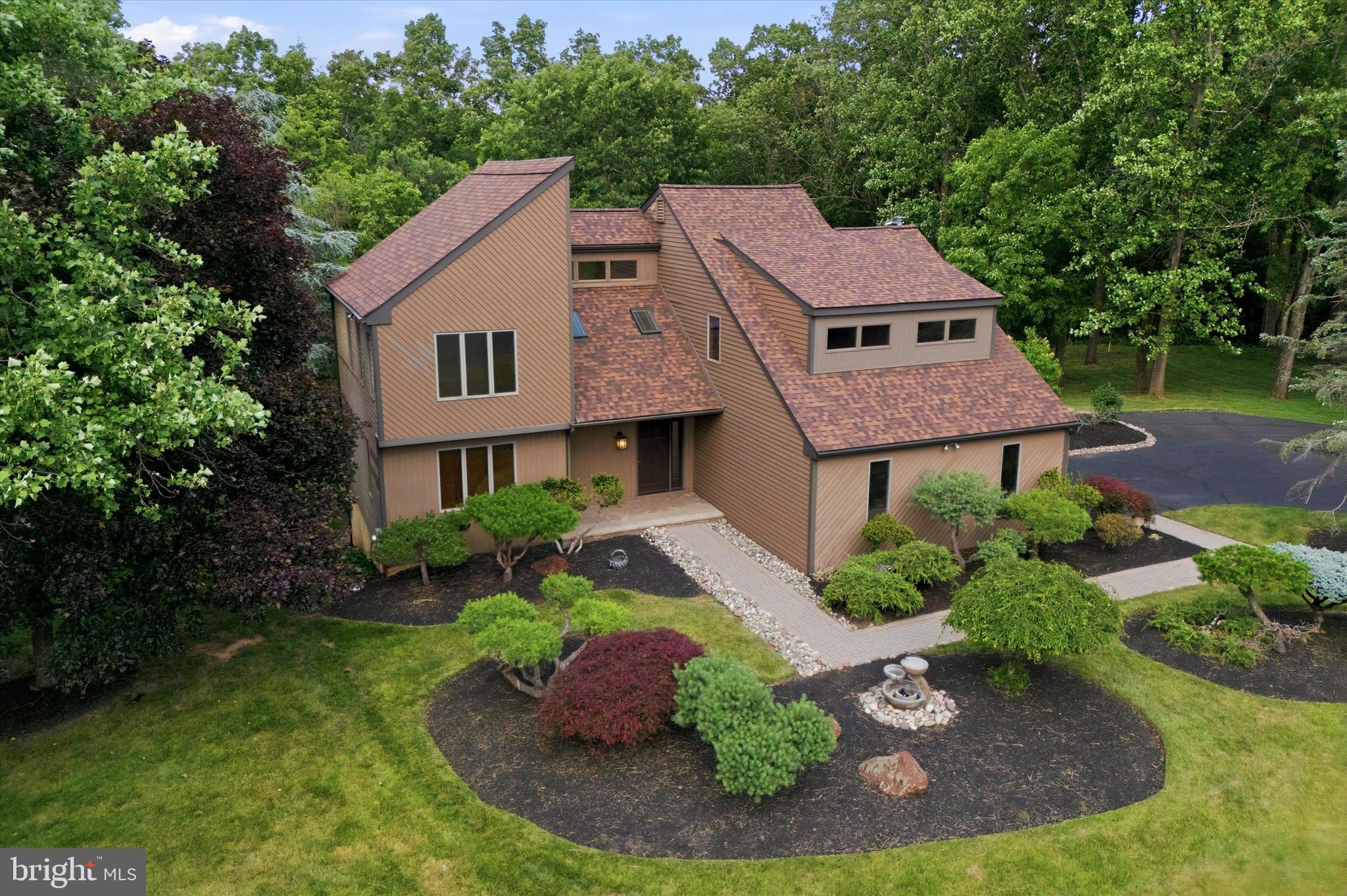 Tucked away at the end of a quiet cul-de-sac in desirable Wrightstown Township, 84 Skoures Lane offers a rare blend of seclusion, natural beauty, and everyday comfort. Set on more than 3 scenic acres within the highly acclaimed Council Rock School District, this contemporary home feels like a private retreat while remaining just minutes from Newtown, New Hope, and convenient access to New Jersey. Surrounded by mature trees, seasonal views, and a gently flowing creek, the setting invites you to slow down and enjoy the surroundings. Inside, natural light fills multiple inviting living spaces designed for entertaining, gathering, or quiet evenings at home. The refreshed kitchen features new appliances and overlooks the beautiful property, bringing the outdoors into daily life. Step outside to the composite deck or expand your possibilities in the finished walkout basement, ideal for a media room, home office, fitness space, playroom, or guest retreat. Upstairs, four generously sized bedrooms offer flexibility and comfort, while the three-car garage and extended driveway provide plenty of parking and storage. More than a home, 84 Skoures Lane offers the space, setting, and lifestyle that make Bucks County so special