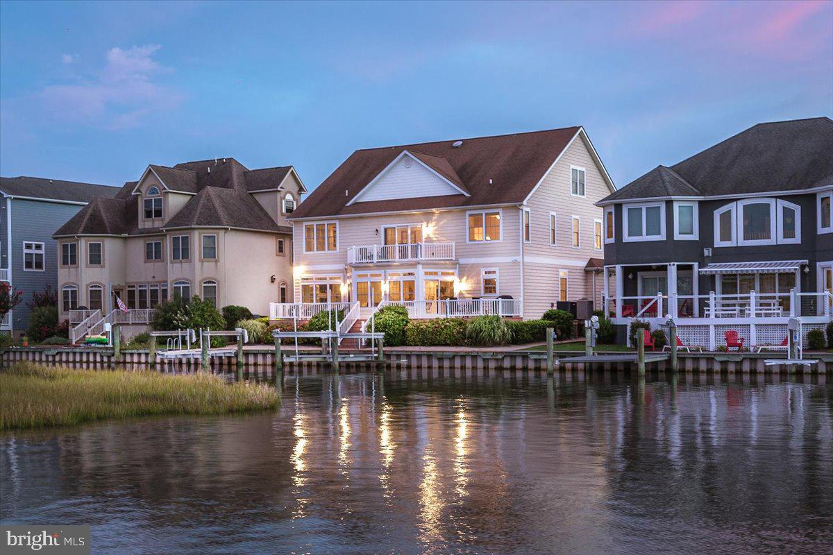 Exquisite custom built 5BR/4.5BA waterfront estate in Ocean City, Maryland hits the market!  Immerse yourself in the ambience of this luxurious waterfront lifestyle while enjoying breathtaking views of the water and enchanting bird sanctuary. This property features exceptional craftsmanship and was custom built by T&G Builders with astute attention to detail. This home is built for the sophisticated buyer looking for custom finishes, such as the grand curved staircase fit for a princess.  This home has plenty of space for family and friends, and features five bedrooms with the master bedroom and bath on the first floor.  The second floor family room is currently being used as a game room but could be a sixth bedroom if needed. There is also a home office perfect for the remote worker in today's world.  The incredible kitchen has granite countertops, stainless steel appliances, high end cabinets, breakfast bar, double ovens,  and many other upgrades. The dining area is off the kitchen and provides expansive water views.  The family room is off the dining room and also overlooks the water. The family room has a gas fireplace for enjoying winter nights relaxing at home.  Enjoy outdoor living with the maintenance free multi-level decks perfect for summertime barbecues, parties, crab feasts, entertaining and relaxing. There's your own private pier with a deep water dock, boat lift, two jet ski lifts and vinyl bulkhead. In the front of the house there is a covered porch creating a warm environment, and the home has been professionally landscaped. This estate offers a fabulous open floor plan that maximizes spectacular views.  There is plenty of storage and you will love the full walk-up steps to the floored attic with high ceilings.  This home is in the amenity rich community of Heron Harbour. The community amenities include an indoor heated pool, outdoor family pool, Olympic size lap pool, kiddie pool, fitness center, library, social room and two lighted clay tennis courts. This is more than a luxurious home, it's a lifestyle. Offered at $1,849,900