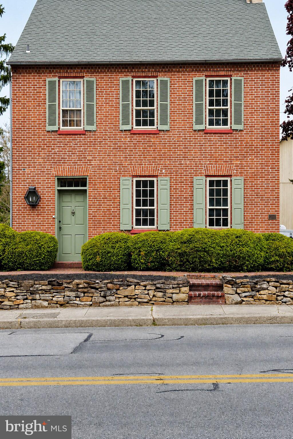 Upcoming Auction June 25th 2026 at 5pm.   
Step back in time with this remarkable 18th-century historic residence, rich in character and architectural charm. Offering approximately 2,445 square feet of living space, this home features 3 spacious bedrooms, 2.5 baths, an eat-in kitchen, family room, formal dining room, and living room.
Original craftsmanship is evident throughout, including hardwood floors, detailed wood moldings, built-in cabinetry, and multiple fireplaces. A welcoming three-season porch with swing provides a relaxing space to enjoy the property’s peaceful setting.
The second floor hosts all bedrooms, accessed by original wooden stairs and banisters. The primary suite includes a full bath with walk-in shower, generous closet space, and convenient laundry area. Additional bedrooms are accessed from the main hallway, along with a cedar closet and attic storage. A third-floor room, historically used as a workman’s quarters, adds further character and versatility.
The home’s grand front entry retains its original hardware and is complemented by a striking corner cabinet just inside. A secondary entrance leads through the three-season room into the kitchen, which also features an impressive original wood door.
Outbuildings & Grounds
A charming brick walkway leads to an exceptional bank barn with a stone and brick foundation, hand-hewn pegged beams, and metal roof. Historically regarded as one of the largest bank barns in Adams County, it once hosted community gatherings and dances.
The lower level of the barn served as the art studio of renowned folk artist Arthur Glazier, known for works such as The Peaceable Kingdom, Victorian Santas, and Noah’s Ark scenes. Today, the barn offers versatile space with parking on both levels and ample off-street parking.
A separate chicken coop—formerly used by Glazier for staging materials—adds additional utility and charm.
The property offers dual access from E. King Street and North Street (rear alley).