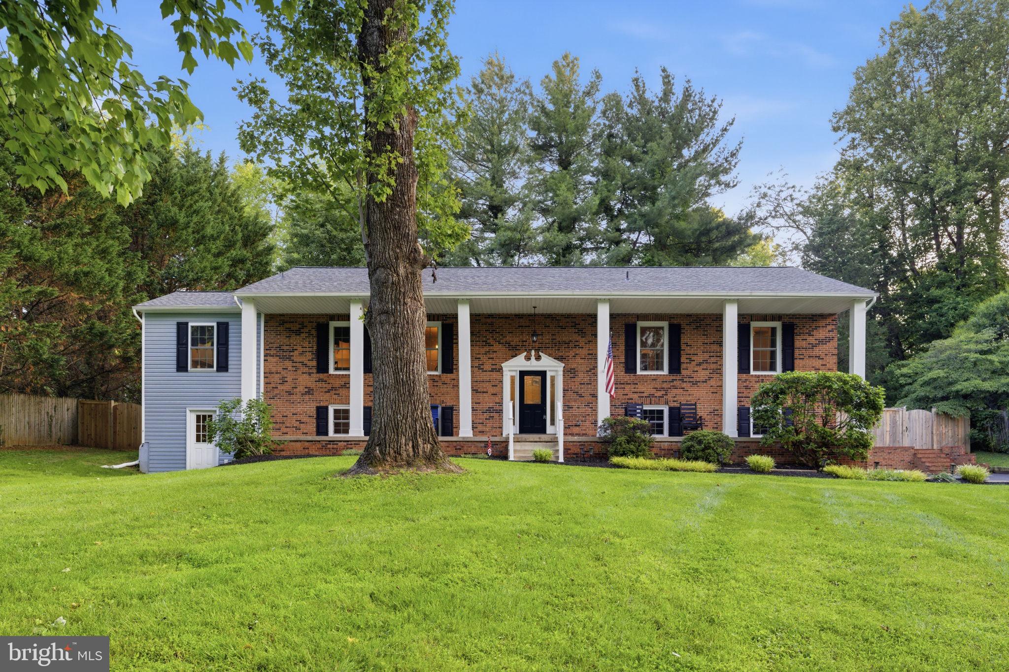 Tucked away on a quiet cul-de-sac in the Millwood subdivision of Warrenton, this extensively renovated 5-bedroom, 3-bath split foyer sits on over an acre of beautifully maintained grounds — offering the privacy, space, and updates today’s buyers are searching for.
In 2017, this home underwent a major renovation: the kitchen was extended with a new layout and design, a bedroom was added to the lower level, new windows and French doors were installed throughout, all flooring was replaced, and the exterior received new siding and a new deck. The result is a home that lives and feels like new while retaining the charm of its solid brick-front construction.
Since the renovation, the owners have continued investing in critical systems and curb appeal — new roof (2022), HVAC ( 2019), paved driveway (2024), fencing (2023), sump pump (2022), and carpet (2020). Very little deferred maintenance remains. Inside, the main level features a spacious extended kitchen, a large living room, formal dining, and three bedrooms. The lower level includes a generous recreation room with a pellet stove, plus two additional bedrooms and a full bath. A drive-under two-car garage adds everyday convenience and storage.
Outside, enjoy the covered front porch stretching the full length of the home, rear deck, and fully
fenced yard — all set on a private, wooded lot of over an acre with no HOA. Located on the DC side of Warrenton with easy access to Rt. 29 and commuter routes, this property is minutes from Old Town Warrenton’s dining and shopping, and within the Fauquier County school system (P.B. Smith Elementary / Warrenton Middle / Fauquier High). A rare combination of location, acreage, and move-in-ready condition.