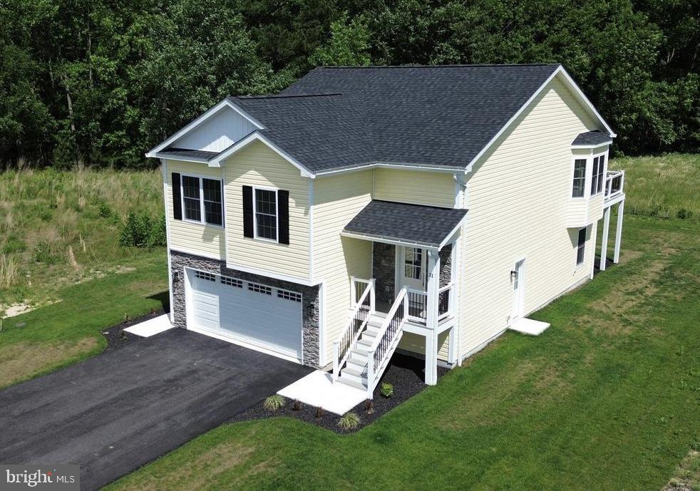 Welcome to 31 Preakness Drive in Ocean Pines' newest neighborhood! This newly constructed 5 bedroom, 3 full bath home is move-in ready and offers over 2,400+ square feet of thoughtfully designed living space and an oversized 2-car garage. The open concept floor plan features luxury vinyl plank flooring, abundant natural light and a beautifully appointed kitchen with stainless steel appliances, custom cabinetry, tile backsplash and a large center island. The spacious primary suite offers a spa-inspired bath with a freestanding soaking tub, custom-tiled shower, dual vanities, and generous closet space. Two additional bedrooms and a full bath are located on the main level, while the lower level includes two bedrooms, a full bath and a large family room. Enjoy the elevated rear deck overlooking a peaceful natural setting. Conveniently located with easy access to Route 50 and just minutes from Ocean Pines amenities, golf, marinas, shopping, dining, historic downtown Berlin and the beaches of Ocean City, providing the perfect blend of coastal living and everyday convenience.