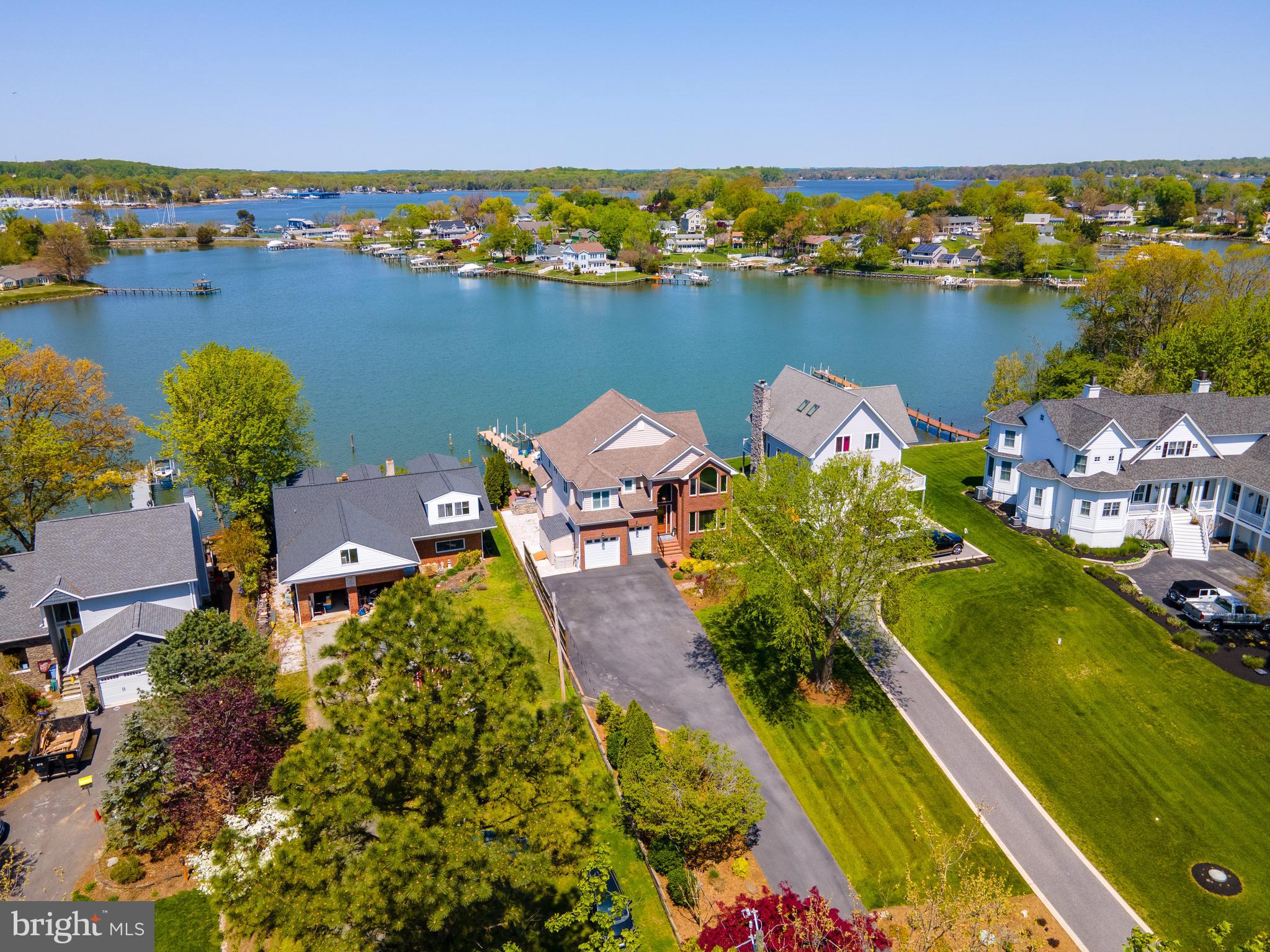 PRICE IMPROVEMENT! Picturesque waterfront. This 6 bedroom, 3 ½ bath home with sweeping views of Ramsey Lake located just off of the South River and Chesapeake Bay has been meticulously maintained with many recent updates. The attention to detail is noted throughout with gorgeous moldings and trim, Brazilian and Canadian hardwood floors, custom built-ins and beautiful plantation shutters. Water views take center stage from nearly every room. Enter the main level through a grand foyer with high ceilings and circular staircase. A formal dining room is located to the right and as you move straight back into the home, you are introduced to the spacious gourmet kitchen with commercial grade appliances, granite countertops and large center island with breakfast bar. The kitchen is open to a circular breakfast room and a two-story great room with custom stone mantle surrounding the fireplace and floor to ceiling windows, designed to maximize natural light and breathtaking water views. Enjoy your favorite beverage on the back porch, located off the breakfast room, while observing all the abundant wildlife West Shoreham Beach has to offer. The open floor plan with multiple gathering areas makes entertaining guests a breeze. The washer and dryer are located on the main floor for convenience. The upper level of the home boasts a master suite, and three additional bedrooms. The luxury owner’s suite offers two walk-in closets, a bay window for enjoying sunsets, a dual sided gas fireplace and a luxurious master bath with dual vanity, frameless glass shower, custom cabinetry, heated towel rack and floors. Easily host your guests with a finished basement offering a sizable wet bar, beverage fridge and sink, theatre room and two private bedrooms (one containing a full bath). The spaces are versatile, so easily convert one of the bedrooms back into a gym, theatre room or play room. This property’s exterior is a perfect place to relax all year round with a spacious waterside deck and patio with Viking grilling. The deck steps down into another inviting outdoor entertaining space with a fire pit. The deep-water pier (MLW 6ft) contains several slips to accommodate multiple boats, a 12,000lb boat lift, a new floating dock to easily launch kayaks and paddle boards, and a jet ski lift. The property is located in the private community of West Shoreham Beach with the popular Mayo Beach Park nearby. This special home is an easy retreat from the heart of Annapolis with close access to Baltimore, BWI Airport and Washington DC. Welcome home to prime waterfront living at its best!