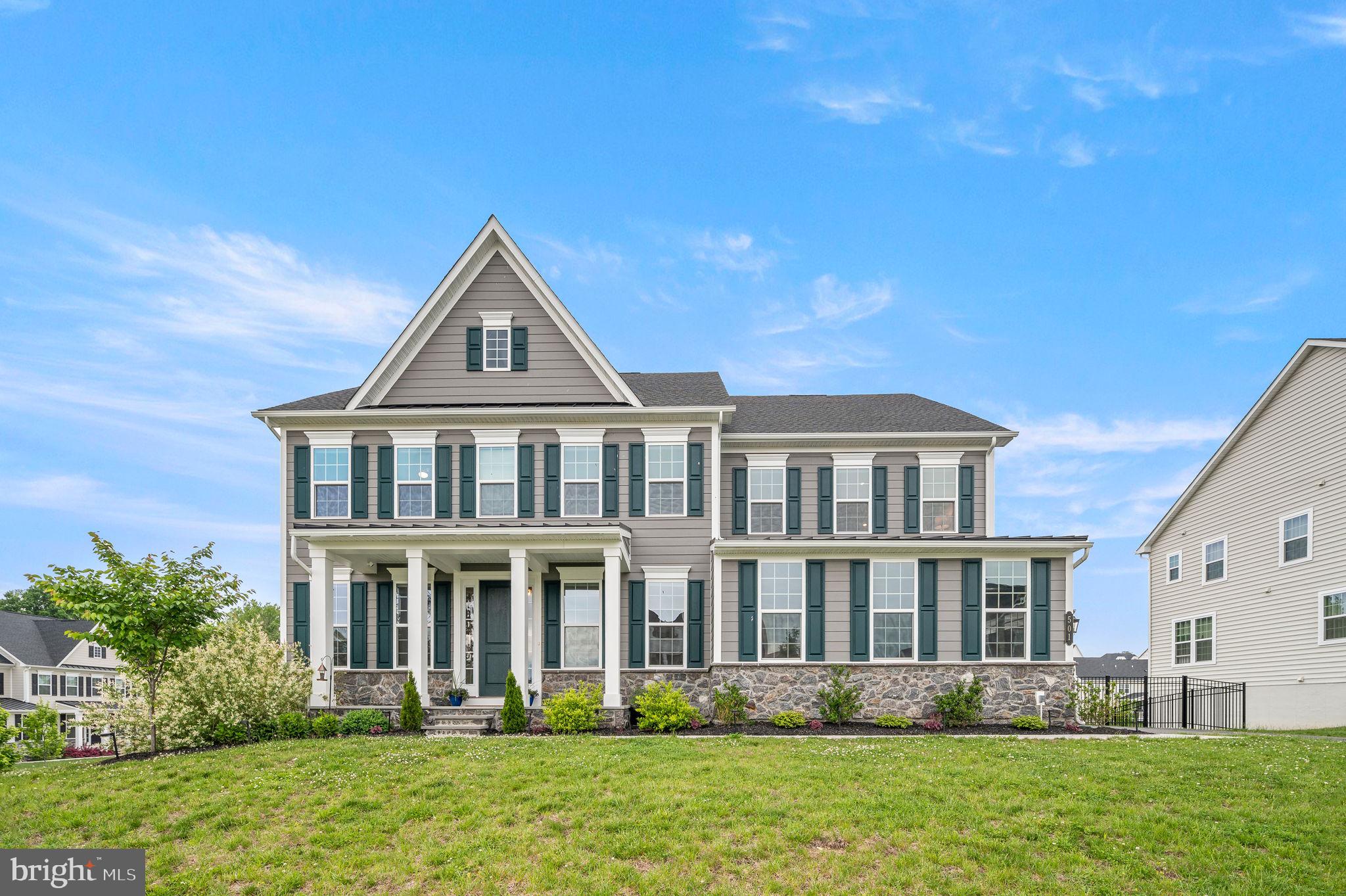 Why wait for new construction when you can step right into this stunning, better-than-new home nestled in the sought-after community of Greystone! Crafted with meticulous attention to detail, this Marymount Model boasts a coveted corner lot, impressive curb appeal, and over $175,000 in upgrades. A welcoming front porch sets the tone for the refined elegance found within. Sunlight pours through expansive windows, highlighting the lustrous hardwood floors that grace the main level. The foyer is flanked by a bonus room with double glass doors and a transom window on one side, and a spacious formal dining room on the other. Beyond the turned stairway lies an open floor plan with abundant space for flexible use. The gourmet kitchen is a chef's dream, featuring premium cabinetry, upgraded quartz countertops, a sizable island, double ovens, additional lighting, and a generous pantry. A charming breakfast room with a coffee bar opens onto an expansive, covered deck, perfect for outdoor gatherings or unwinding at day's end. Steps from the deck lead to the sizable, fenced backyard. Indoors, the generously-sized family room radiates comfort and charm, complemented by a convenient gas fireplace to cozy up chilly winter nights. A private office offers a serene workspace for remote days, while a powder room and custom mudroom with built-ins add convenience on the main level. Hardwood floors grace the stairs and hallway of the second floor, leading to the luxurious owner's suite boasting dual walk-in closets, a tray ceiling, sitting area, and spa-like bath with a soaking tub, dual vanities, and a spacious shower. Guest bedrooms offer comfort and privacy, with two sharing a bathroom, while the fourth bedroom features an en-suite bath. A bright laundry room completes the second floor. The walk-out finished basement provides endless entertainment possibilities, with space for a game room, gym, and second family room. The fifth bedroom, with direct access to a full bath, offers privacy for long-term guests. In addition to the large two-car garage, the sellers opted for a third garage bay. This immaculately maintained home is conveniently located just minutes from the charming borough of West Chester, renowned for its dining, specialty shops, weekly farmer’s market, and community events. The community of Greystone features access to a 163-acre nature preserve, three lakes, and nearly seven miles of walking trails. Don’t miss out on the opportunity to own this incredible home—move in, unpack, and indulge in the luxury of Greystone living! Showings begin Friday, 5/17, at 11:00AM