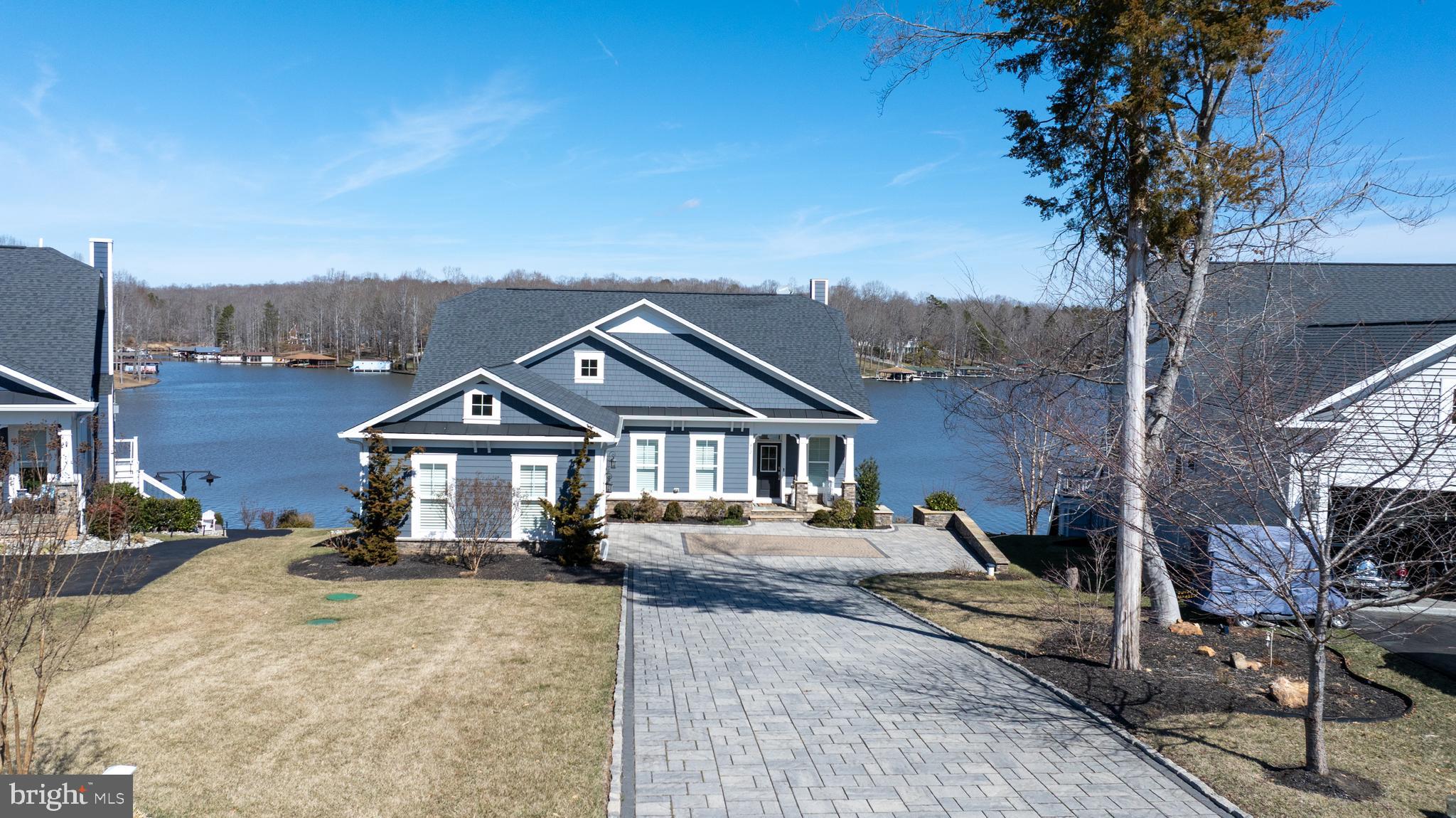 BE SURE TO CHECK OUT THE VIDEO! Stunning Modern Waterfront Lake House with Breathtaking Views! This designer-inspired waterfront property exudes elegance and modern living. Located in the highly sought after and amenity filled SUNSET COVE on the PUBLIC SIDE OF LAKE ANNA! Many furnishing to convey, making it easier for you to move in and start making memories! As you step inside, you're greeted by an open concept layout that seamlessly combines style and functionality. The heart of the home is undoubtedly the gorgeous gourmet kitchen, featuring high-end appliances, countertops and designer lighting that is sure to impress! The spacious family and dining area boasts a full 180 degree view of the shimmering lake! Notice the vaulted ceiling with wood beams, creating an airy and expansive feel. The gas fireplace with soaring stone accent serves as a focal point,  and beautiful engineered hardwood floors flow seamlessly throughout! Step outside to discover an expansive deck with live-edge wood bartop! Take the scenic walkway leading to the magnificent double decker boat house, ideal for endless summer fun! Head down to the lower level featuring a covered deck, sundeck, two boat slips with electric lifts. Did I mention two jet skis and the pontoon boat? Yes, all conveying as part of this incredible package.  Back inside, the primary bedroom is a tranquil sanctuary, offering great waterviews and a plush spa-like en suite. Additional bedroom, full bath, pantry, and convenient laundry room, to include washer/dryer and sink completes the main level. Upstairs, a delightful loft, with more water views, two bedrooms and a Jack-and-Jill bath means plenty of space for everyone! The lower level is a true entertainers dream, showcasing a lovely kitchenette featuring a kegerator, wine cooler, loads of cabinets and counter space, all adding to the modern feel. Enjoy movie nights, compete in a friendly game of pool, ping pong or darts. Additionally, there are two spacious bedrooms, each with well appointed bathrooms. Heading out to the patio expands even more entertainment options. Furnished with ceiling fans and heaters, for year around use. And don't forget the beautiful fire-pit, ready for your enjoyment, night after night! Let's not forget to mention the stone driveway, professional landscape, stone and boulder hardscape, surround sound, alarm, the list goes on. Let's talk about SUNSET COVE amenities. They include inground swimming pool, clubhouse, workout room, nature trails, pickleball, 14 foot boat launch, and lawn care! Also, your new home promotes a relaxed lifestyle WITHOUT THE INTERFERENCE OF  SHORT TERM RENTALS, ensuring a peaceful environment where you can truly unwind and connect with friends, family and neighbors! Don't miss your opportunity to make this beautiful retreat your own! Measurements are estimated.