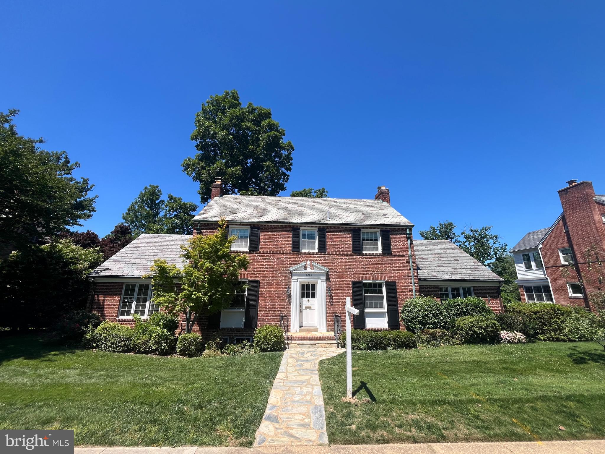 Stunning, stately 4,000sf Colonial featuring five bedrooms, four full bathrooms and a convenient main level powder room. A flagstone walkway leads to an inviting front door and a center-hall style foyer with gleaming hardwood floors. Grand proportions throughout include a vaulted ceiling sunroom with three walls of windows, as well as a living room and dining room that stretch the full depth of the home. The eat-in chef’s kitchen features soaring, vaulted ceilings, quartz countertops, and stainless steel appliances including a professional-grade six-burner gas cooktop. Kitchen overlooks the backyard, has a bar area, a built-in desk and abundant pantry storage. Four bedrooms and three full bathrooms on the upper level, including a luxurious primary suite and a secondary princess suite. Upper level laundry and pull down stairs for attic access. Walk-out lower level features a large great room with a brick fireplace, a fifth bedroom with a sliding glass door to a private rear patio, and the fourth full bathroom. Lower level also includes abundant built-in cabinetry and a large utility room with tons of storage. This gorgeous home sits on a 105-foot-wide, oversized 0.265-acre (11,550 sq ft) lot with mature plantings and a multi-zone irrigation system. Driveway parking for multiple cars and an attached two-car garage in the rear of the home offers additional storage or space for vehicles.
