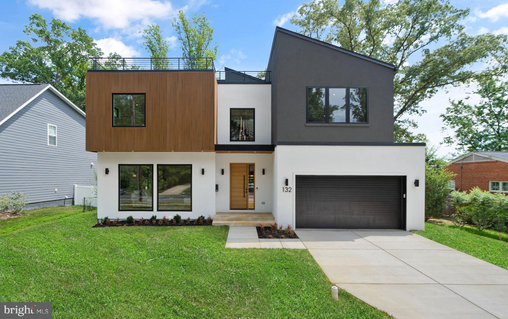 Step into this stunning 5-bedroom, 5.5-bathroom contemporary new build in the sought-after Vienna Woods neighborhood, where luxury meets convenience. Newly built by Mabna Construction, this property offers the perfect blend of modern design and quality craftsmanship. The main level features 10' ceilings, a spacious living room with oversized Andersen windows, an open family room, a sunlit dining area, and a gourmet kitchen including a Calacatta Valentin Quartz waterfall island with seating, custom cabinets, stunning Zellige Perla Polished backsplash, a 48” JennAir range with dual ovens, a 42” refrigerator, two dishwashers, and two sinks. The exquisite Red Oak see-through stairs are detailed with 4” treads and metal stringers, a true show stopper. The main level also boasts 5" Red Oak Hardwood floors, a two-sided see-through fireplace, and West Elm light fixtures. Upstairs, the primary bedroom suite is a haven with its 13' ceiling, luxurious spa-inspired en-suite bath featuring marble shower walls and floors, two shower heads and a rain shower, and large dual walk-in closets custom made with solid Birch and Pine wood. This level also includes three additional bedrooms, each having their own private bathrooms accented with stylish Ivory Square Porcelain walls, plus a convenient laundry room with a sink and storage space. The lower level boasts 9' ceilings and offers versatility with a private 5th bedroom, full en-suite bathroom, a home gym, and an open recreational space with a wet bar, featuring Midnight Corvo Quartz waterfall countertops, custom built wine & spirit display, and solid wood petit style cabinetry. The flooring is waterproof wide plank LVP, and the entire home is wired with Cat 6 and HDMI for TV and entertainment areas. The true WOW factor in this home is the 1,100 sq ft rooftop lounge, offering breathtaking views with ample space, perfect for hosting events or enjoying with the household. Additional features include a large 2-car garage with driveway parking, a rear deck for dining or grilling, and a beautifully manicured level backyard, ideal for outdoor activities. Located just around the corner from the Vienna Metro, Tysons, and the vibrant Mosaic District, this home offers easy access to urban amenities and major highways such as I-66, I-495, and Rt. 123. This new construction is the perfect canvas for creating your dream lifestyle. Schedule a tour today!